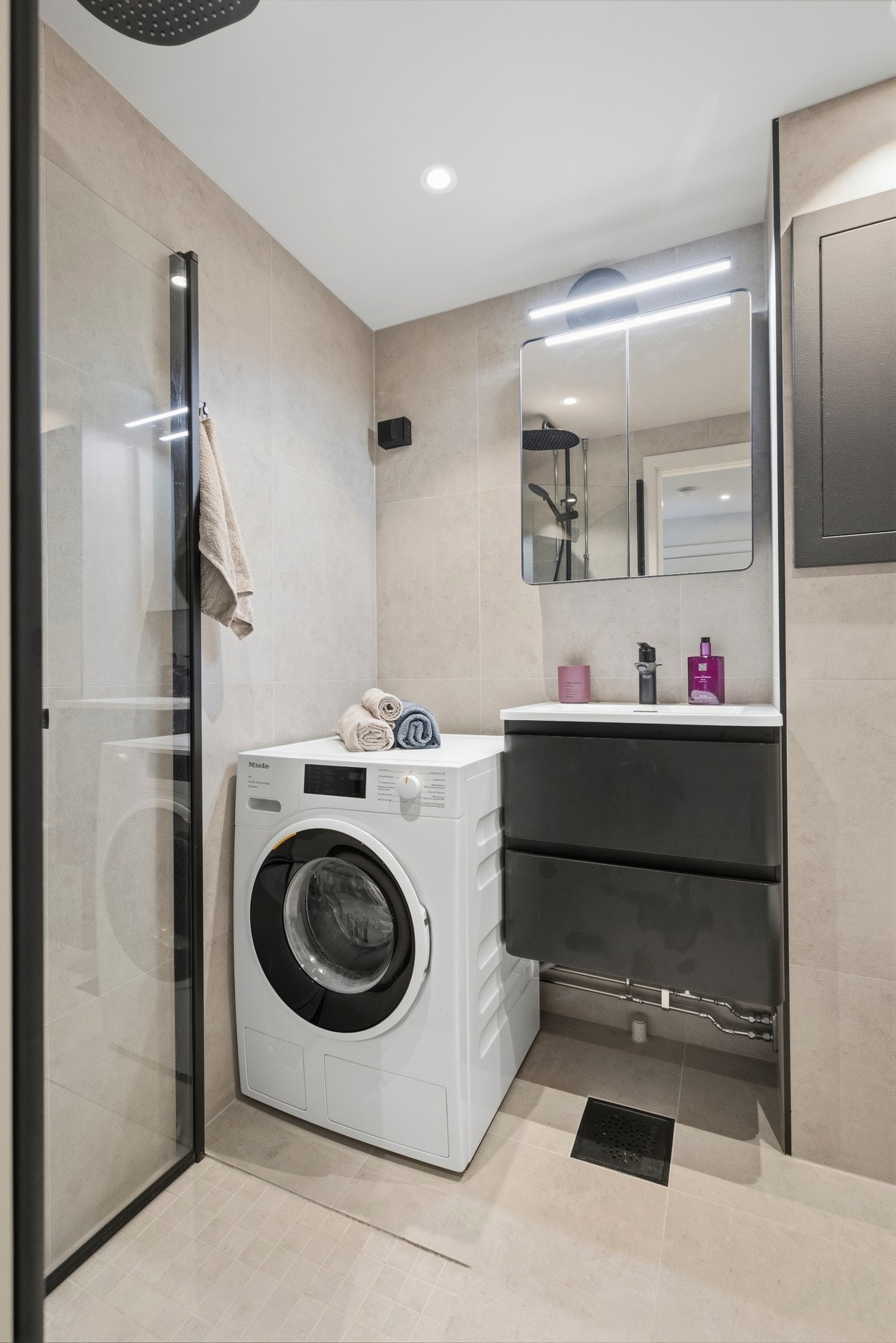 Badet har servant på
vegghengt servantskap (2025) og vegghengte dusjdører i glass (2025).
Opplegg for vaskemaskin. Galleribilde