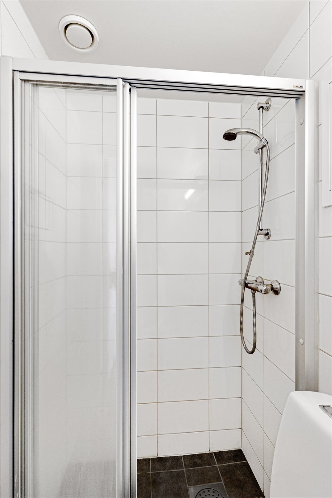 Badet er innredet med WC, dusjplass med vegger og servant med ettgreps blandebatteri i innredning. Galleribilde