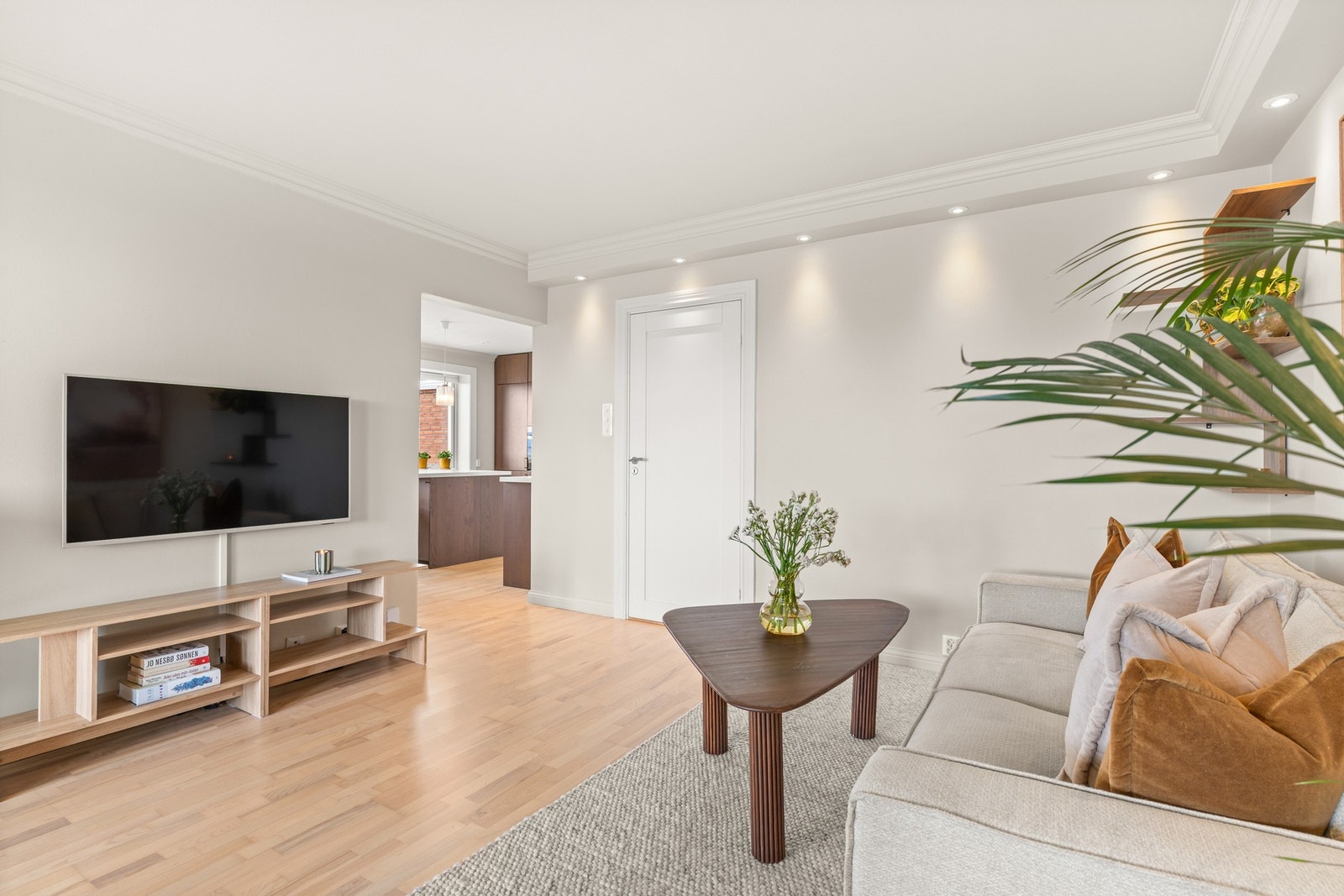 Lyse overflater og parkettgulv gir et moderne og tidløst uttrykk. LED-downlights (fra 2025) med dimmer i stue og kjøkken. Galleribilde