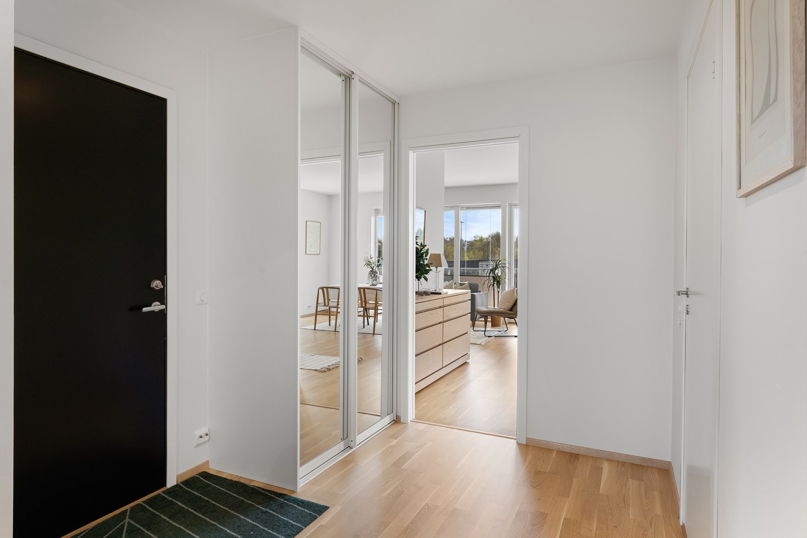 Entréen har en lyd- og brannklassifisert dør og god plass til oppbevaring i en romslig skyvedørsgarderobe. Galleribilde