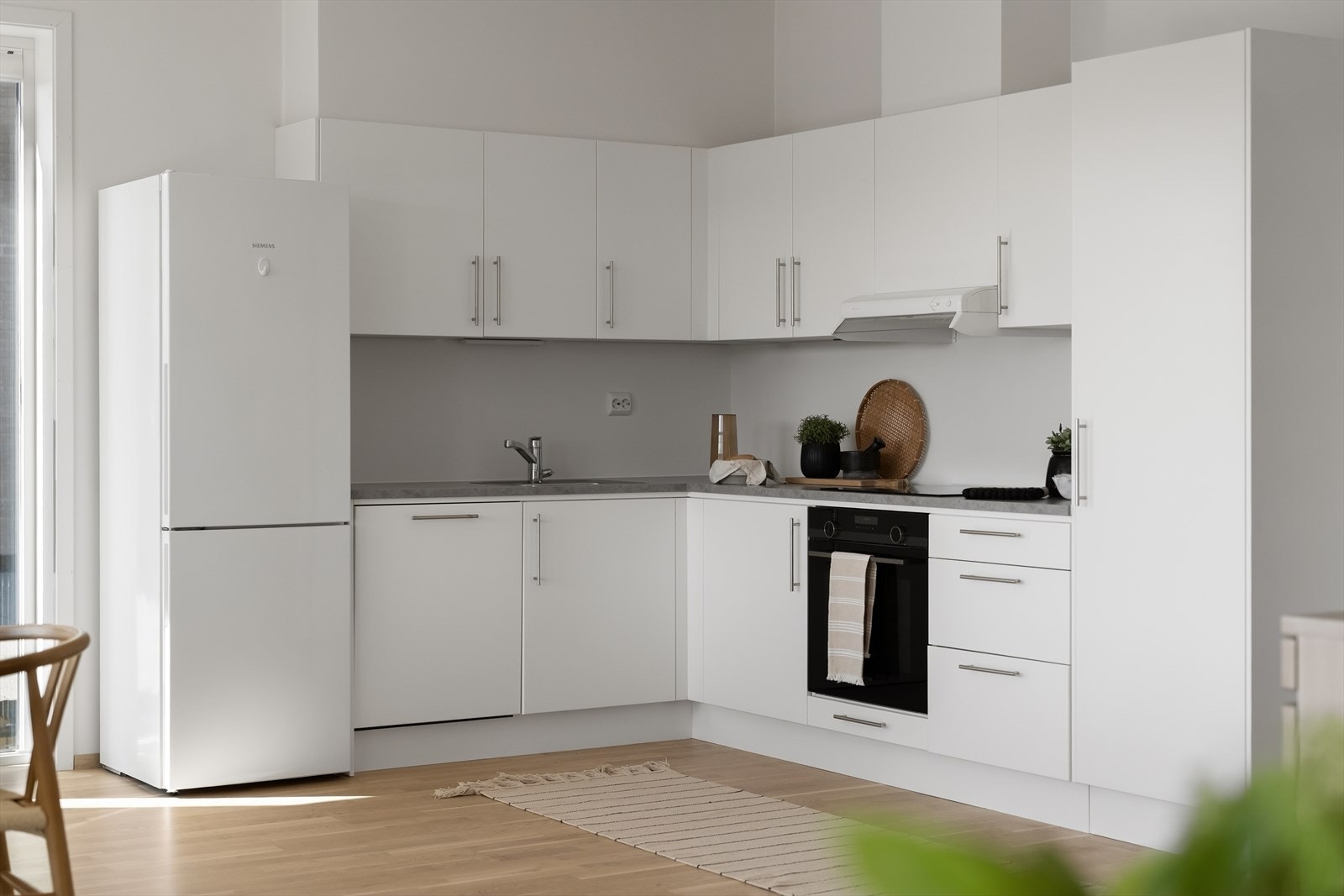 Kjøkkeninnredning med glatte fronter og benkeplate i laminat. Avtrekket er koblet til boligens mekaniske ventilasjonsanlegg. Galleribilde