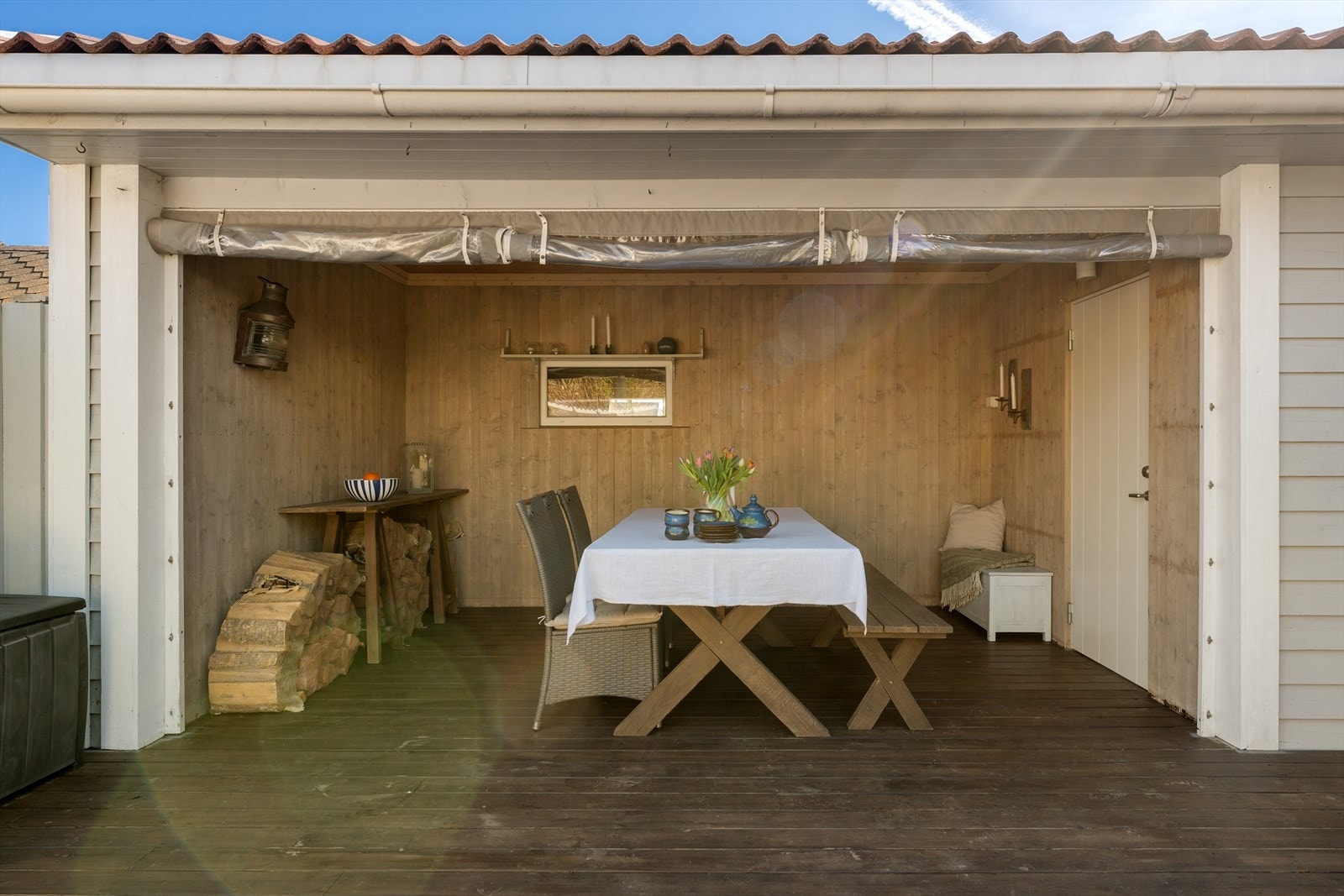 I bakkant av garasjen er det laget til en hagestue hvor det er terrassedekke og panel på veggene. Galleribilde