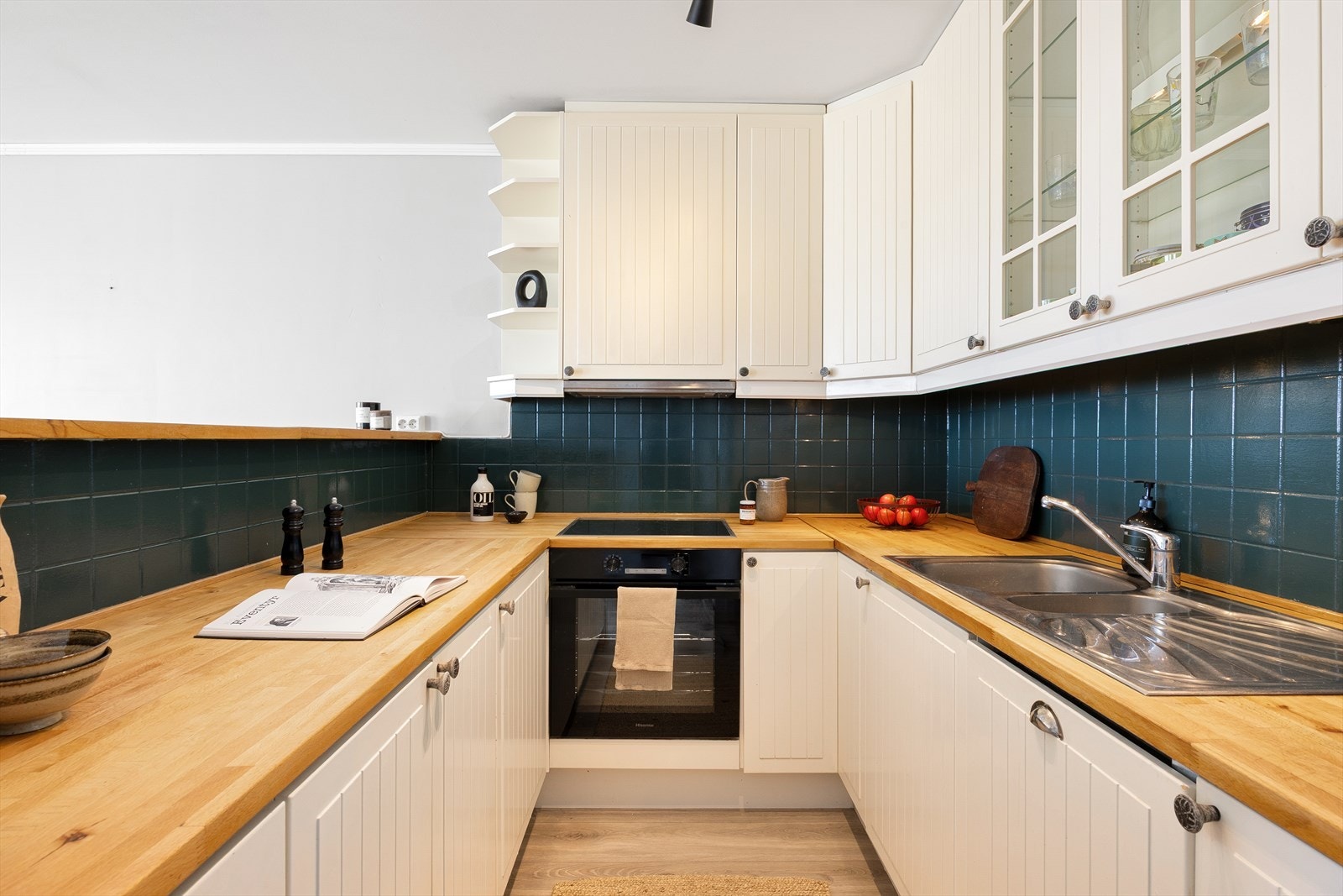 Kjøkkeninnredning fra Ikea med profilerte fronter og benkeplater i heltre. Kjøkkenet har integrert stekeovn, platetopp, oppvaskmaskin og automatisk vannstopper. Galleribilde
