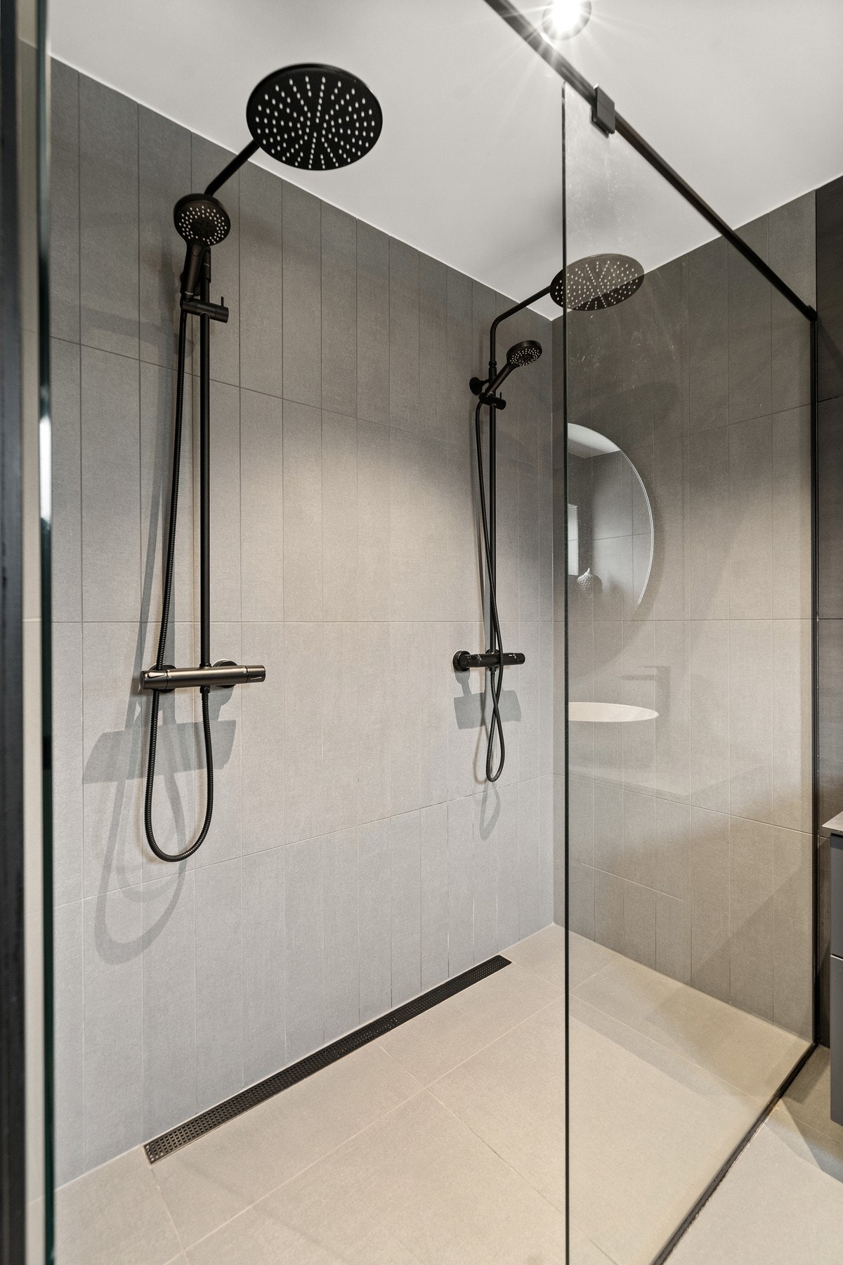 lle badene har gulvvarme, downlights og detaljer i sort utførelse, som armaturer, dusjløsninger og vegghengte toaletter. Badet i andre etasje ligger i tilknytning til hovedsoverommet i en praktisk suiteløsning. Galleribilde