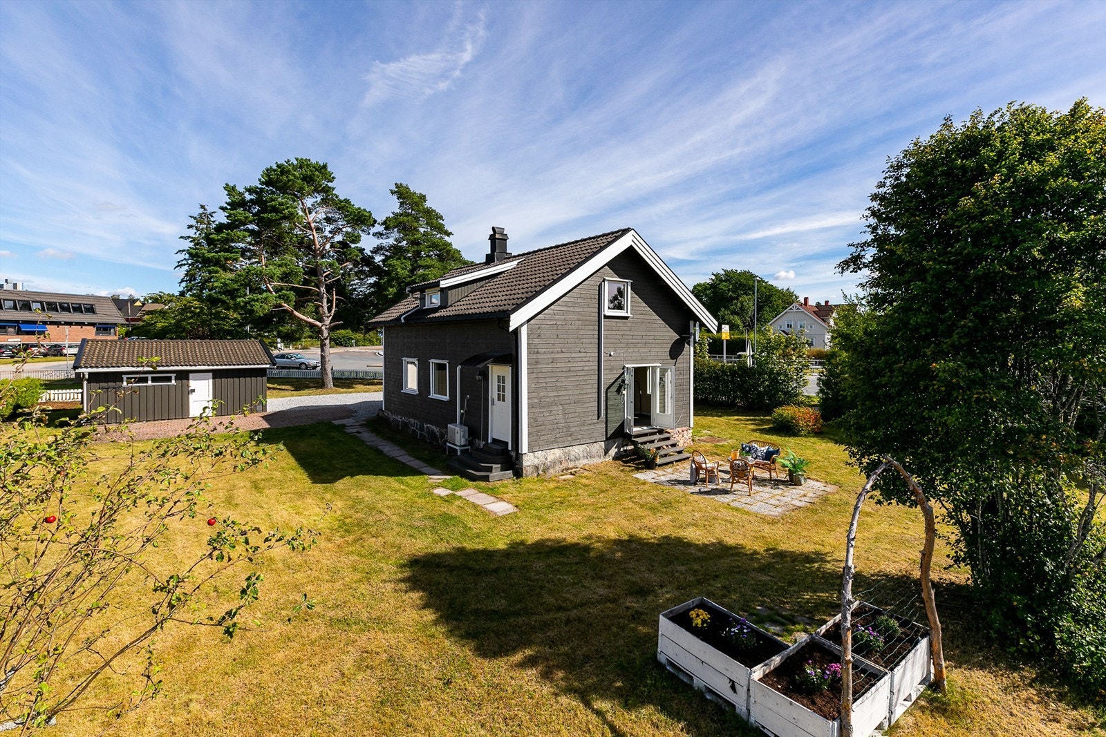Tomten er pent rammet inn av både hekkbeplantning og et hvitmalt stakittgjerde. Galleribilde