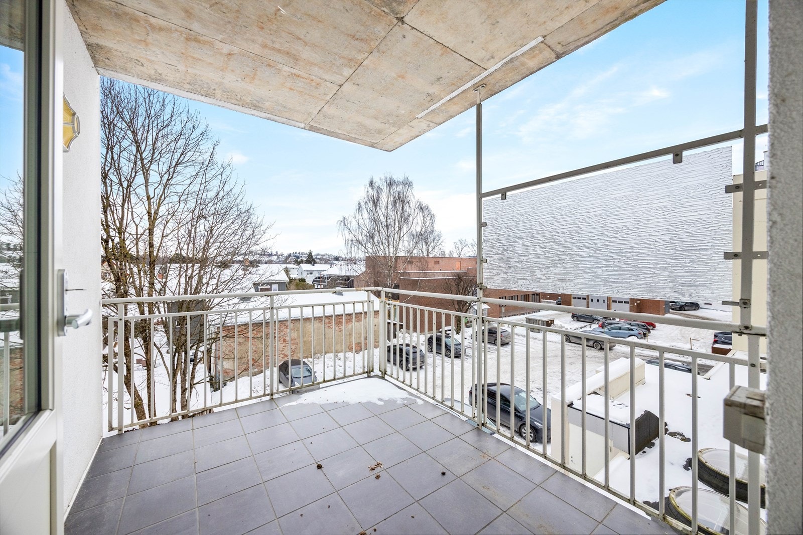 Balkongen har flislagt gulv og rekkverk i metall med skjerming mot naboer. Galleribilde