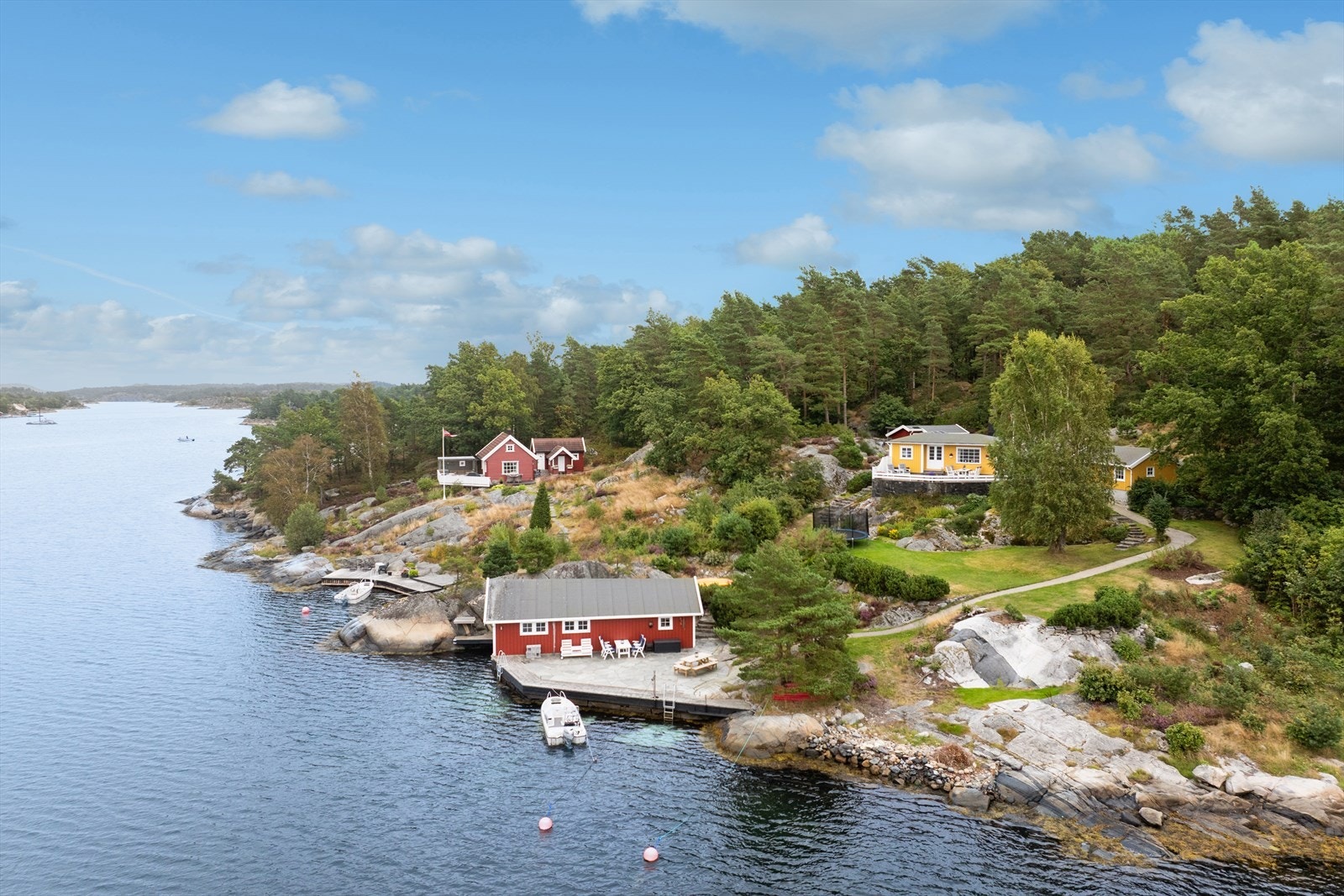 Her får du en komplett fritidseiendom med flere bygninger, store uteområder og umiddelbar nærhet til sjøen. Galleribilde