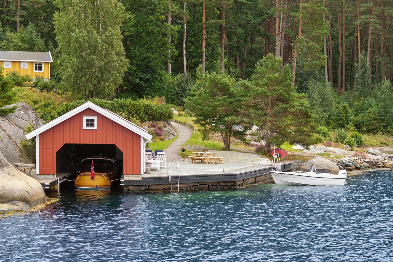 Til eiendommen hører et solid båthus på 56 m² med en tilhørende brygge på ca. 70 m². Galleribilde