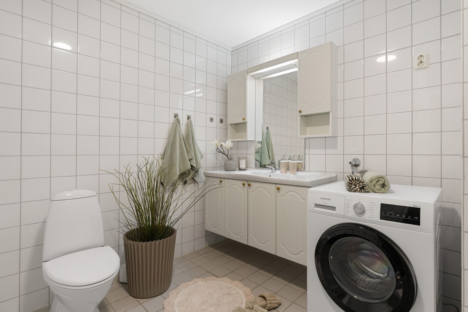 Øvrig innredning består av opplegg for vaskemaskin, badekar, dusjnisje, toalett og et romslig baderomsmøbel med god plass til toalettartikler. Galleribilde