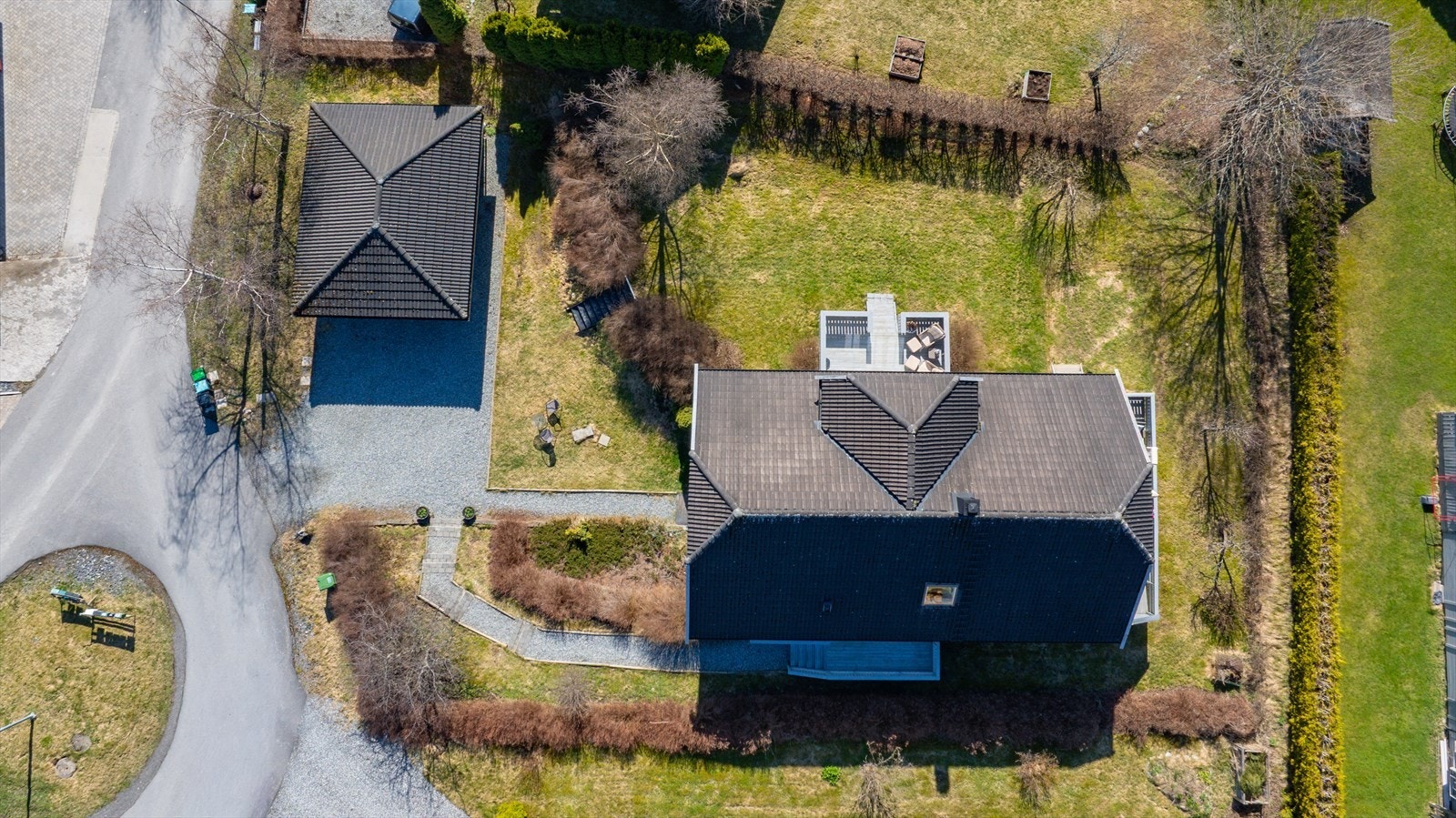 Oversiktsbilde som viser boligens plassering på tomten, med garasjen og den store gårdsplassen. Galleribilde