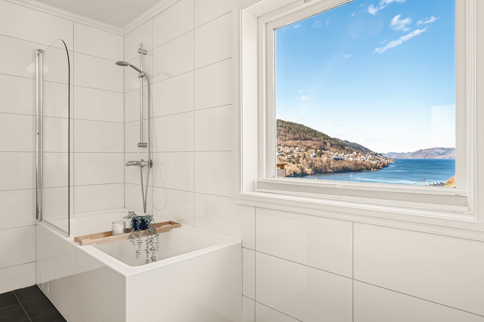 Badet i første etasje er utstyrt med badekar, servant med møblement og veggmontert wc. Galleribilde