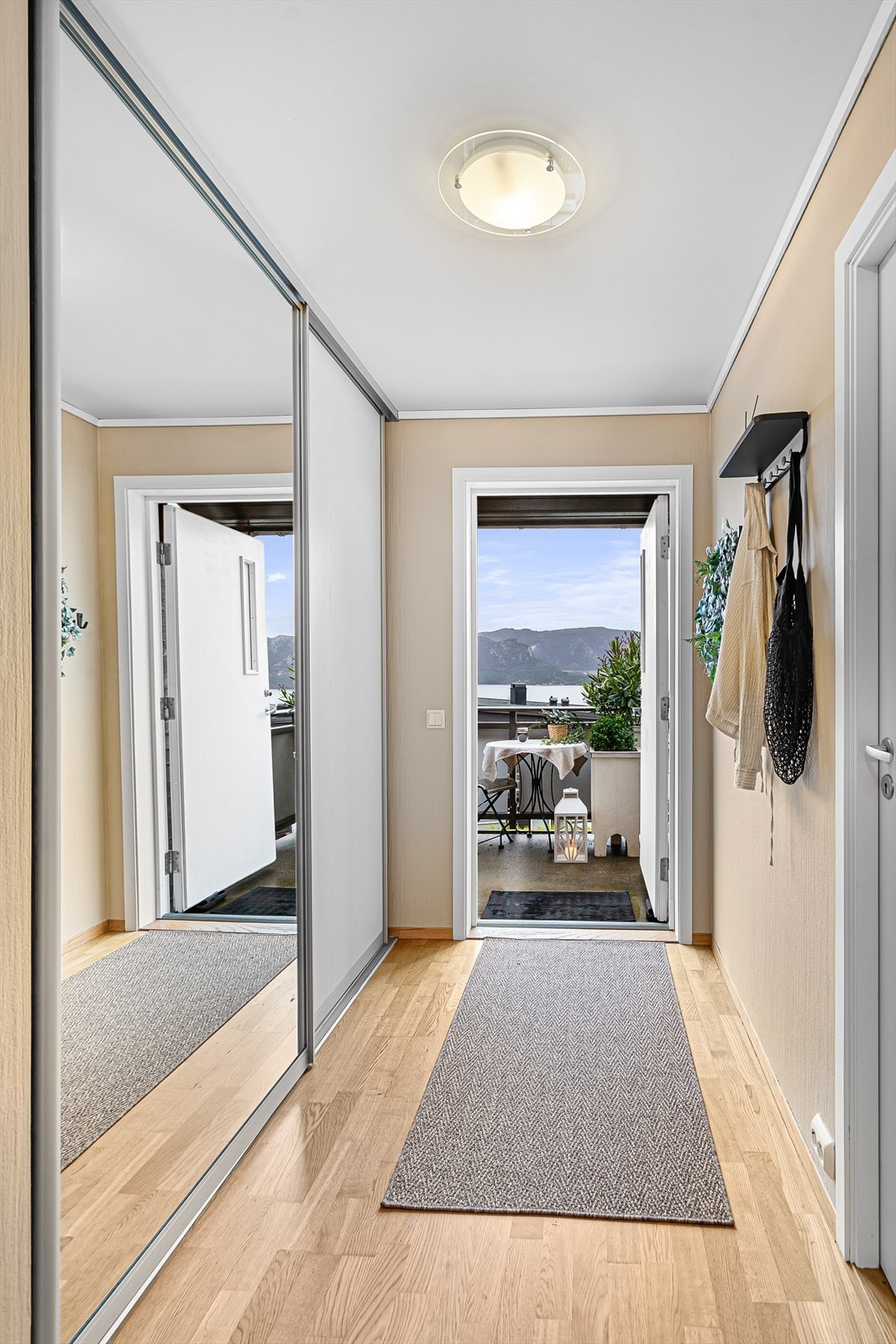 Gang med praktisk skyvedørsgarderobe til yttertøy Galleribilde