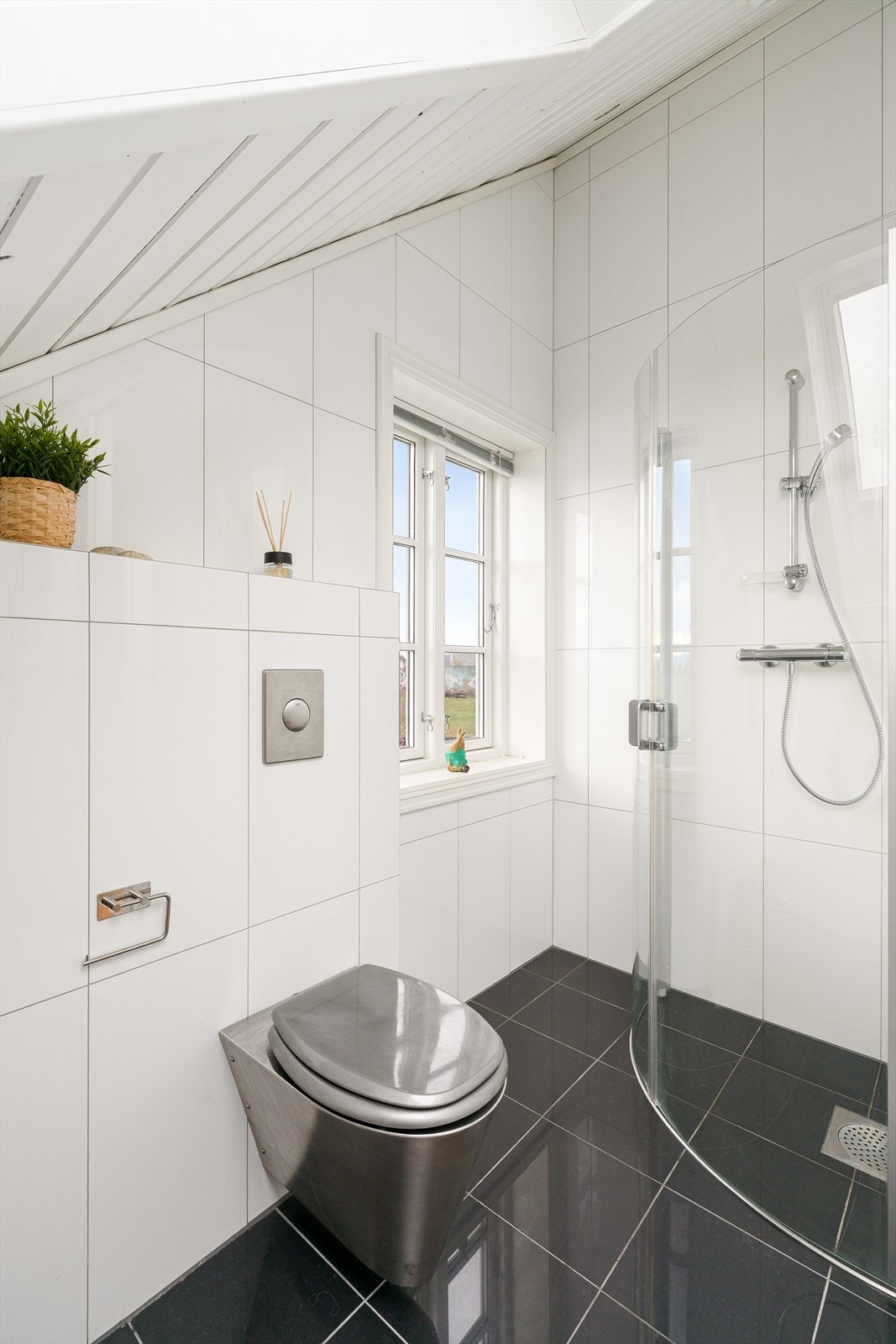 Badet har vegghengt toalett og en dusjnisje med glassdør. Takvinduet gir et flott, naturlig lys. Galleribilde