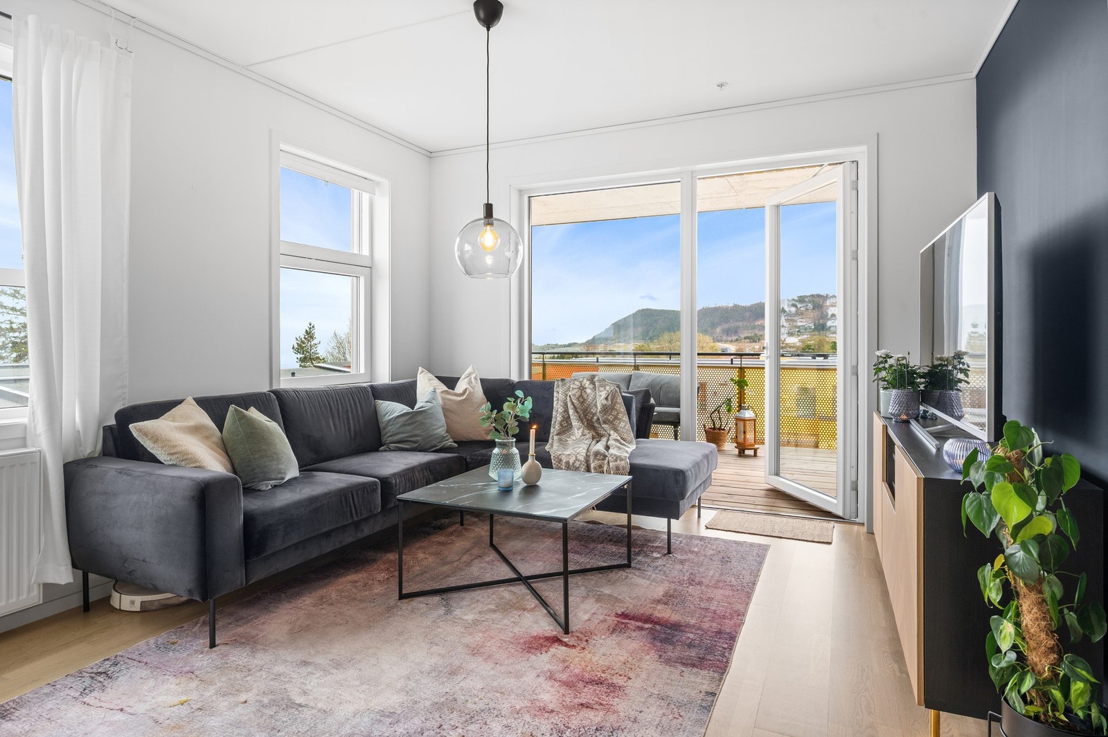 Leiligheten har et moderne uttrykk med store vindusflater på flere sider som, sammen med den gode takhøyden, bidrar til en lett og luftig atmosfære. Galleribilde