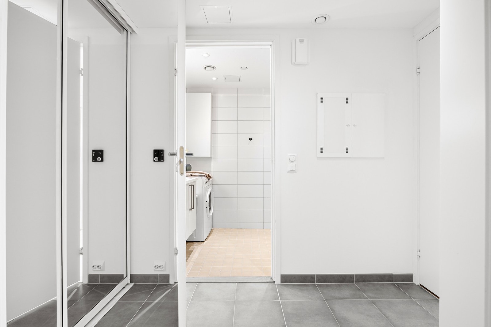 Flislagt entré med gulvvarme og praktisk skyvedørsgarderobe med speilfronter. Galleribilde