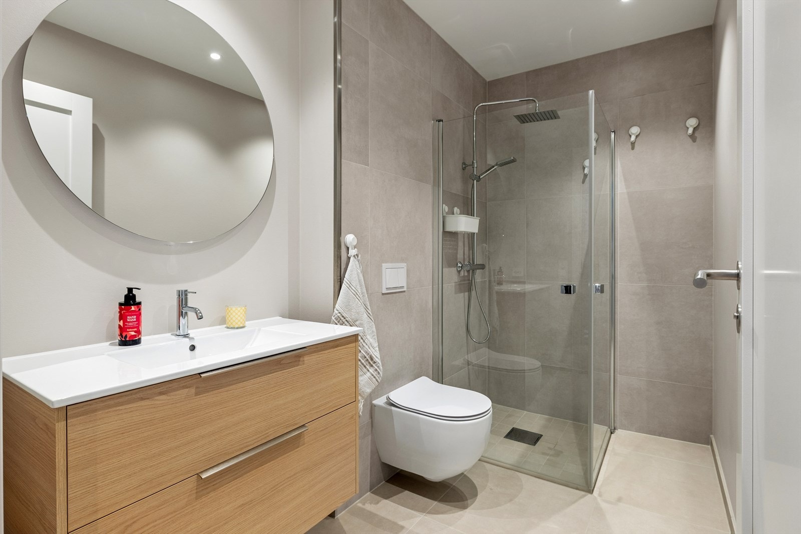 Leiligheten har to delikate bad. Dette badet har vegghengt toalett, dusjhjørne med glassdører og en stilren innredning. Galleribilde
