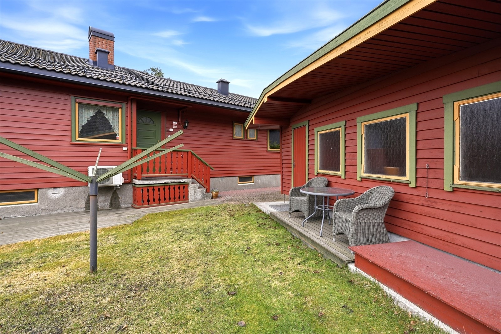 Eiendommen har uteplass også mot sydvest, lunt beliggende på baksiden av huset. Inngangspartiet avbildet i bakgrunnen. Galleribilde