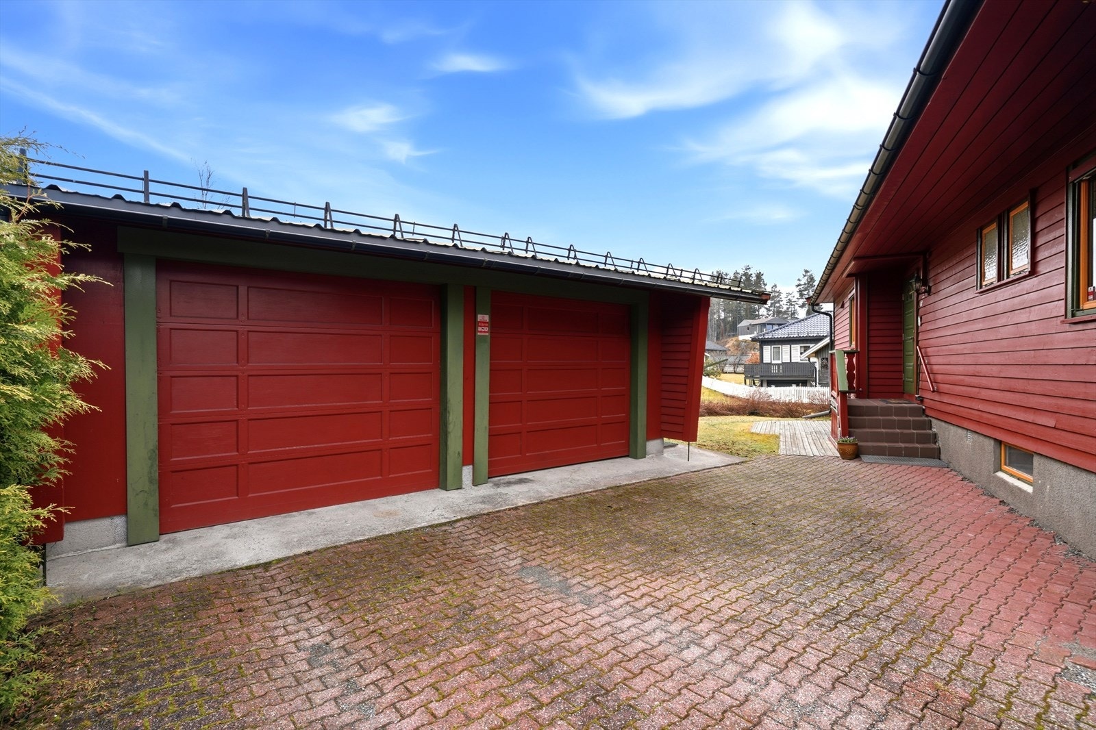 Garasjebygningen er av eldre type, med rommer plass for å kunne lagre diverse utstyr til eiendommen. Belegningsstein utenfor inngangspartiet. Galleribilde