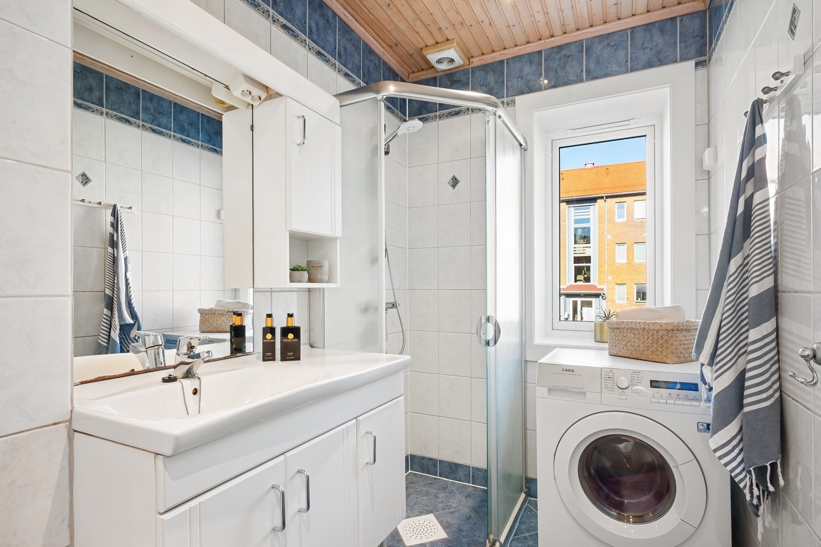 Badet har flislagte overflater med behagelig gulvvarme, samt himling i trepanel med integrerte downlights. Galleribilde