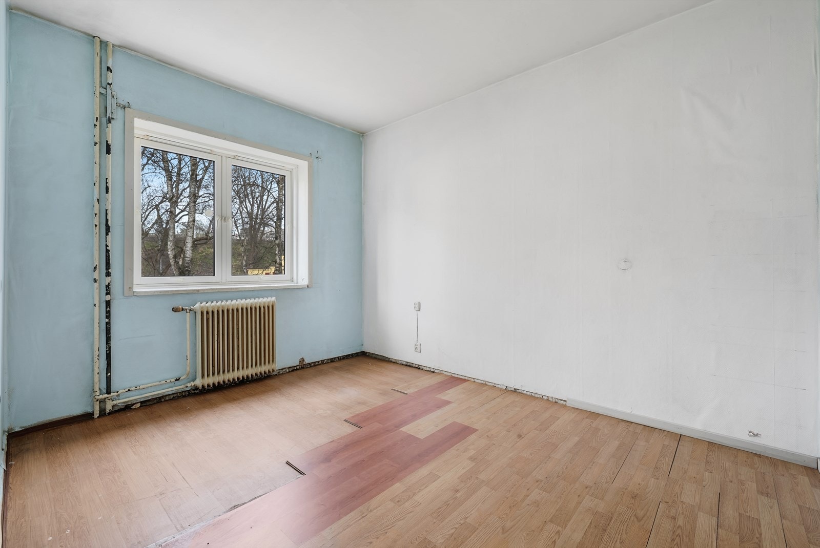 Romslig soverom som varmes opp med vannbåren varme fra en original radiator. Galleribilde