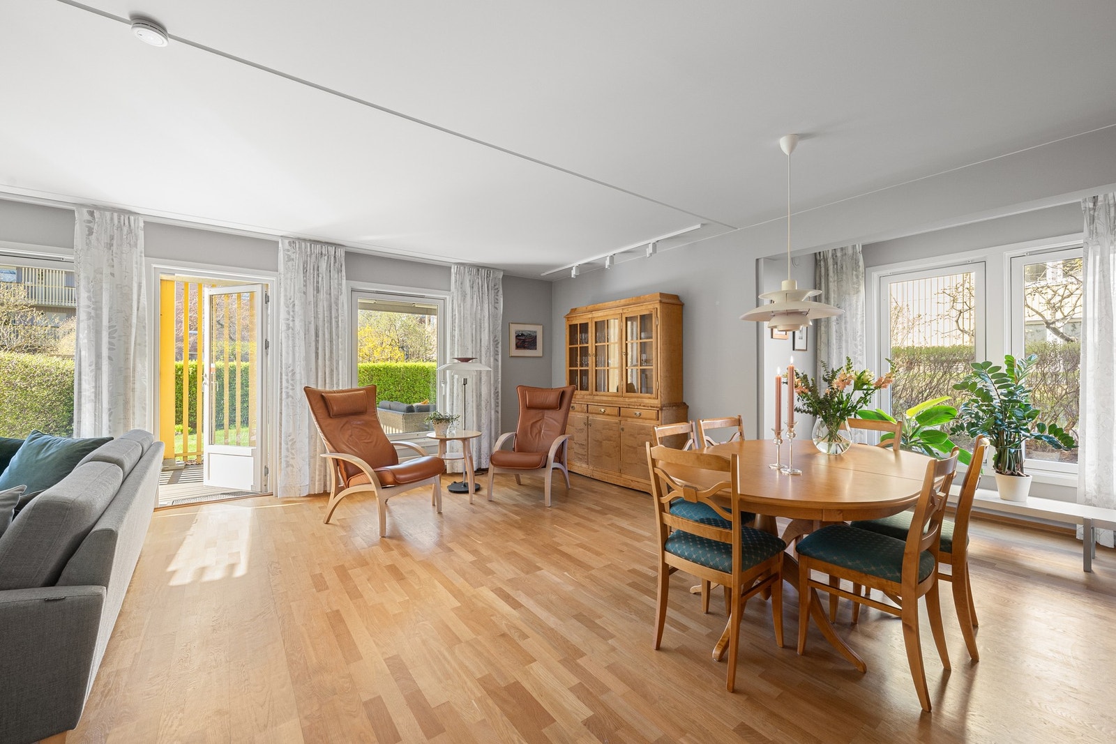 Vinuer på to sider av stuen sørger for mye naturlig lys inn i leiligheten. Galleribilde