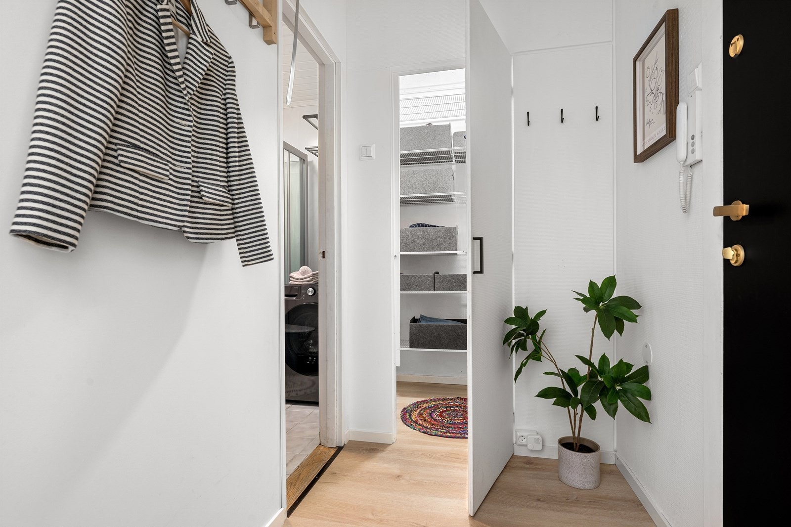 Innbydende entré med smakfulle overflater og adkomst til en innvendig bod/walk-in closet Galleribilde