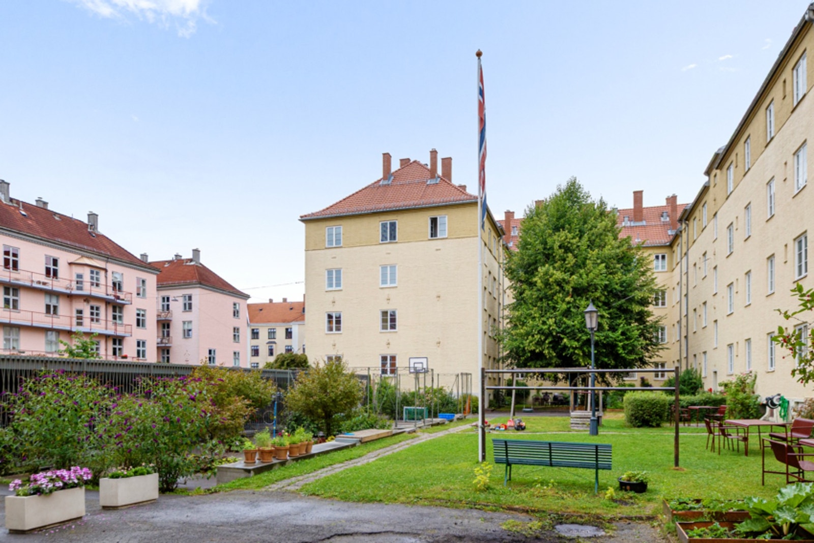 Stor, grønn bakgård med lekeapparater og aktive naboer Galleribilde