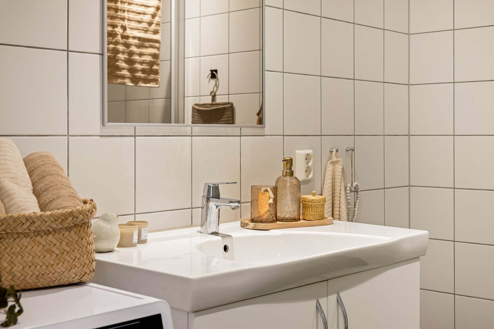 Badet er innredet med en pen baderomsinnredning med nedfelt servant, som gir gode oppbevaringsmuligheter og en ryddig fremtoning. I tillegg er det opplegg for vaskemaskin. Speil på vegg bidrar til å forsterke romfølelsen. Galleribilde