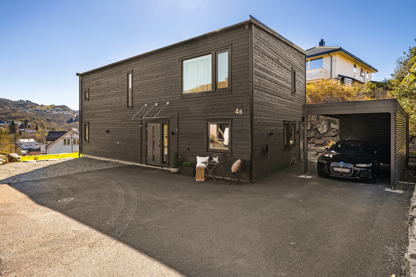 Det er godt med parkeringsplass på eiendommen, blant annet i carporten hvor det også er installert el-bil lader. Galleribilde