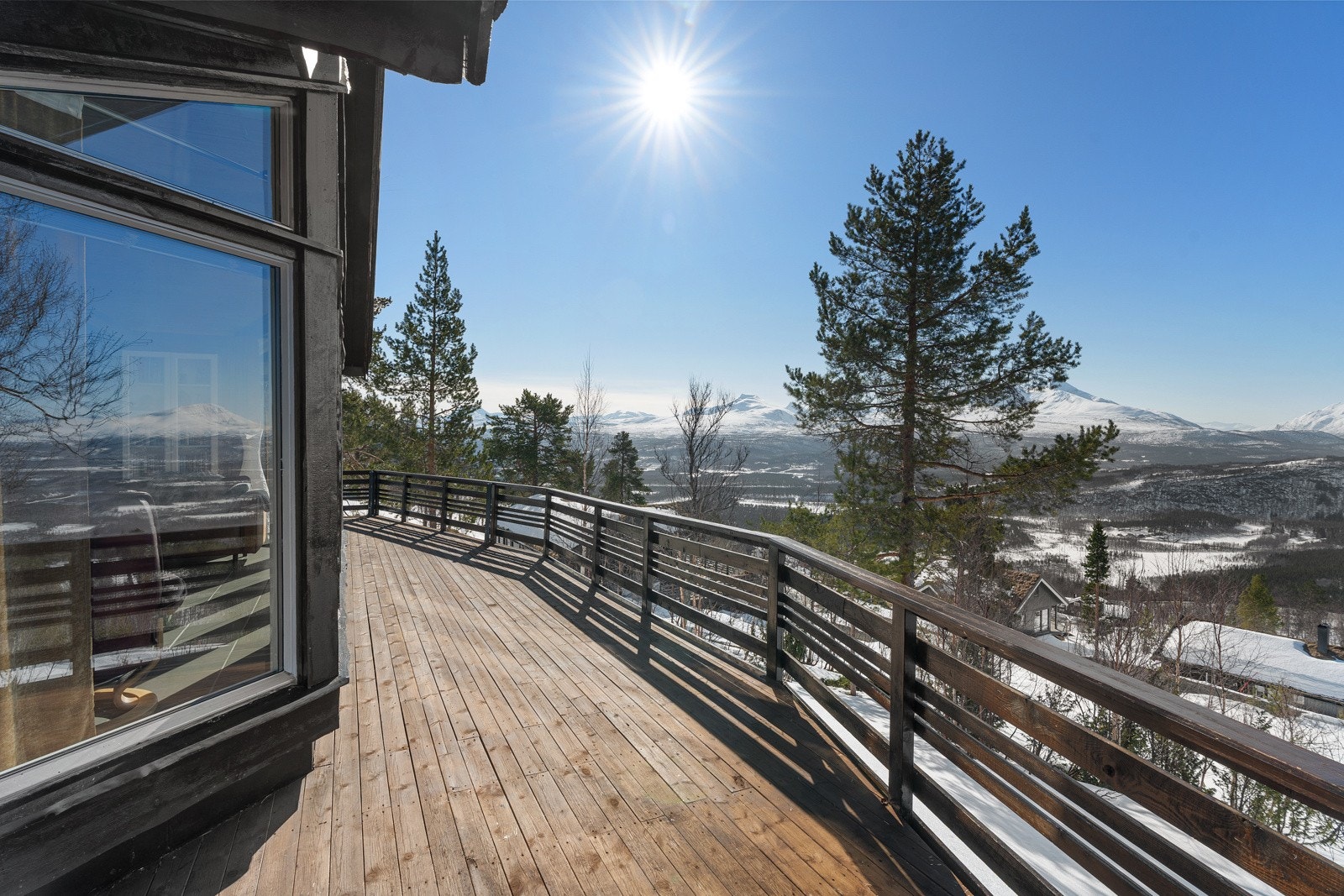 Romslig balkong som går rundt vestsiden og sørsiden av hytta!