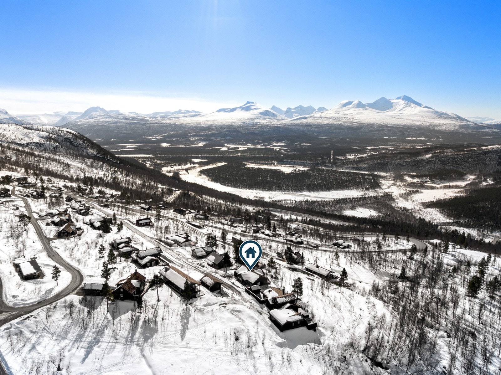 Hytten ligger på skrående tomt mot vest, med opparbeidet parkering.