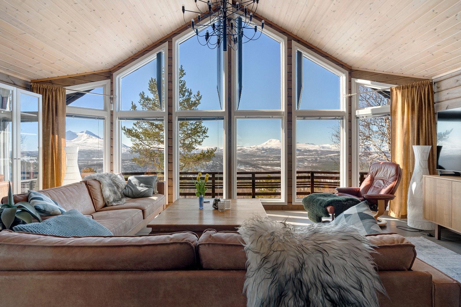 Svært romslig stue med fantastisk takhøyde og store vindusflater.