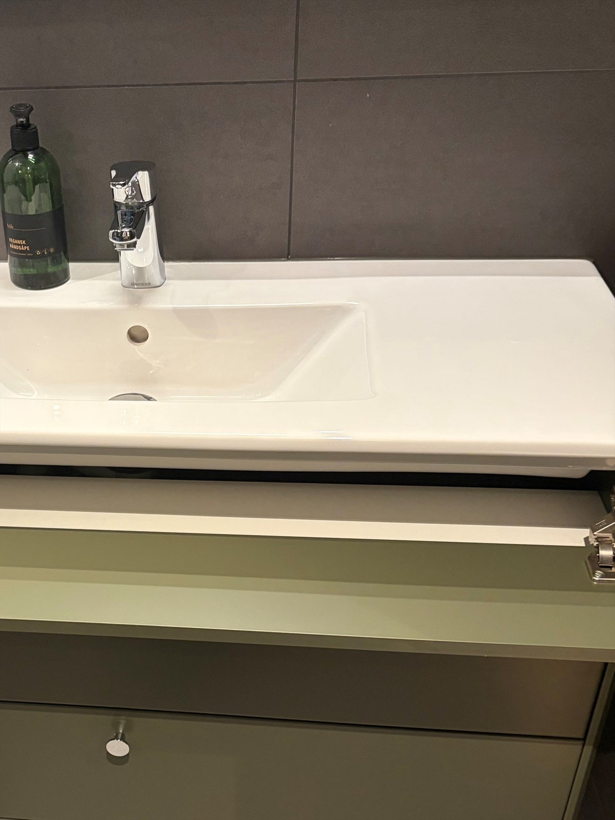 Innredningsdetalj bad - Begge bad i leiligheten har innredning med skjult rom for oppbevaring bak blindfelt under servant. Galleribilde
