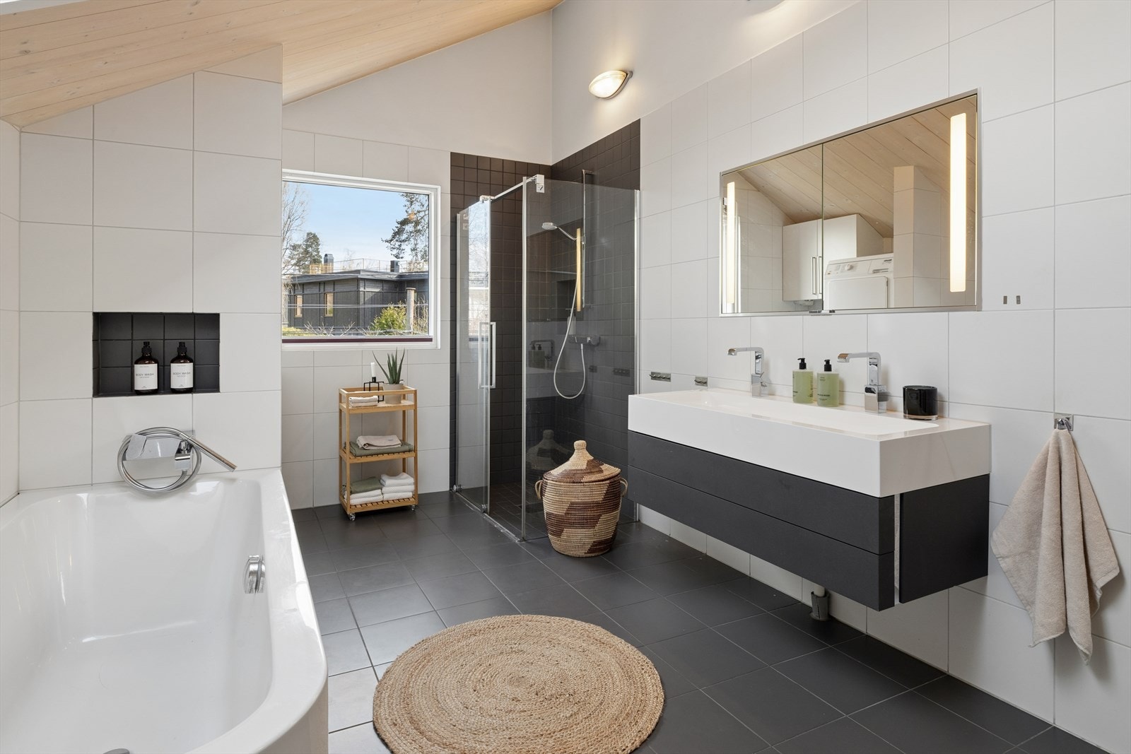 Badet i 2. etasje er et plassbygd baderom fra byggeår, utført med flislagte vegger og gulv, kombinert med synlige flater av massivtre i himling. Galleribilde