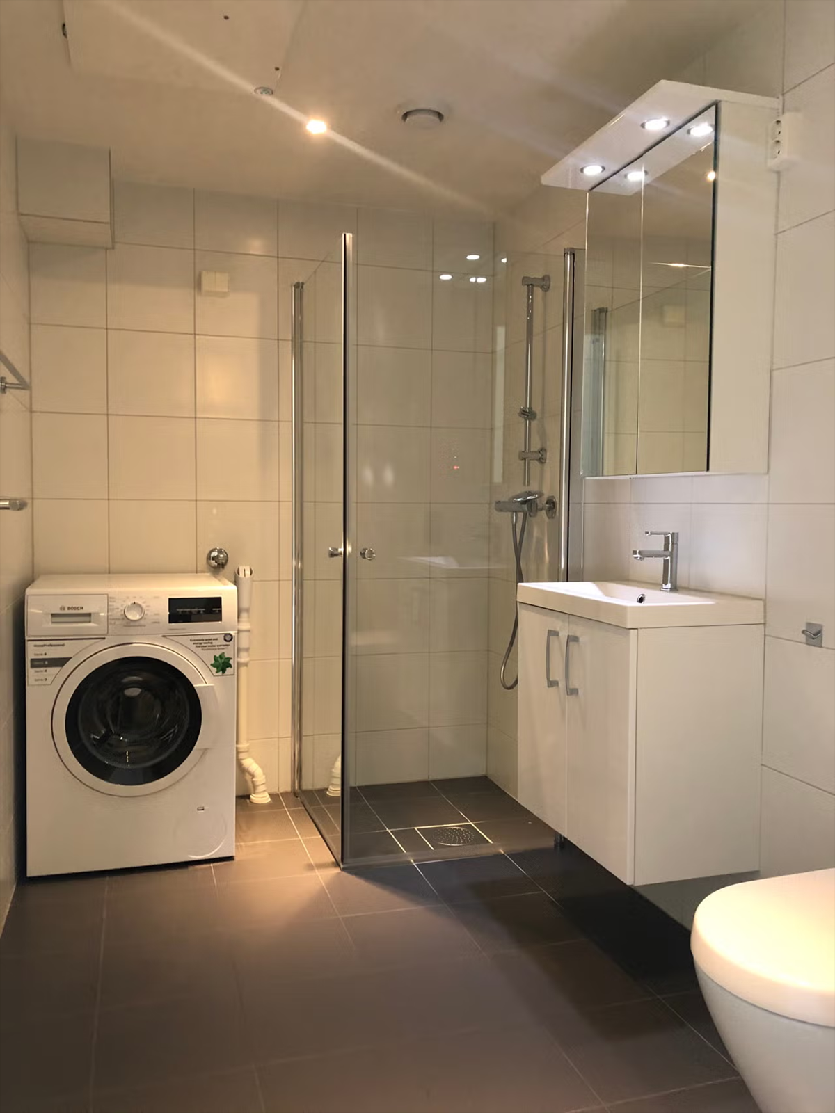 Badet i hybelenheten er flislagt og har vannbåren gulvvarme samt innfelt belysning i himling. Vaskemaskin medfølger handelen. Galleribilde