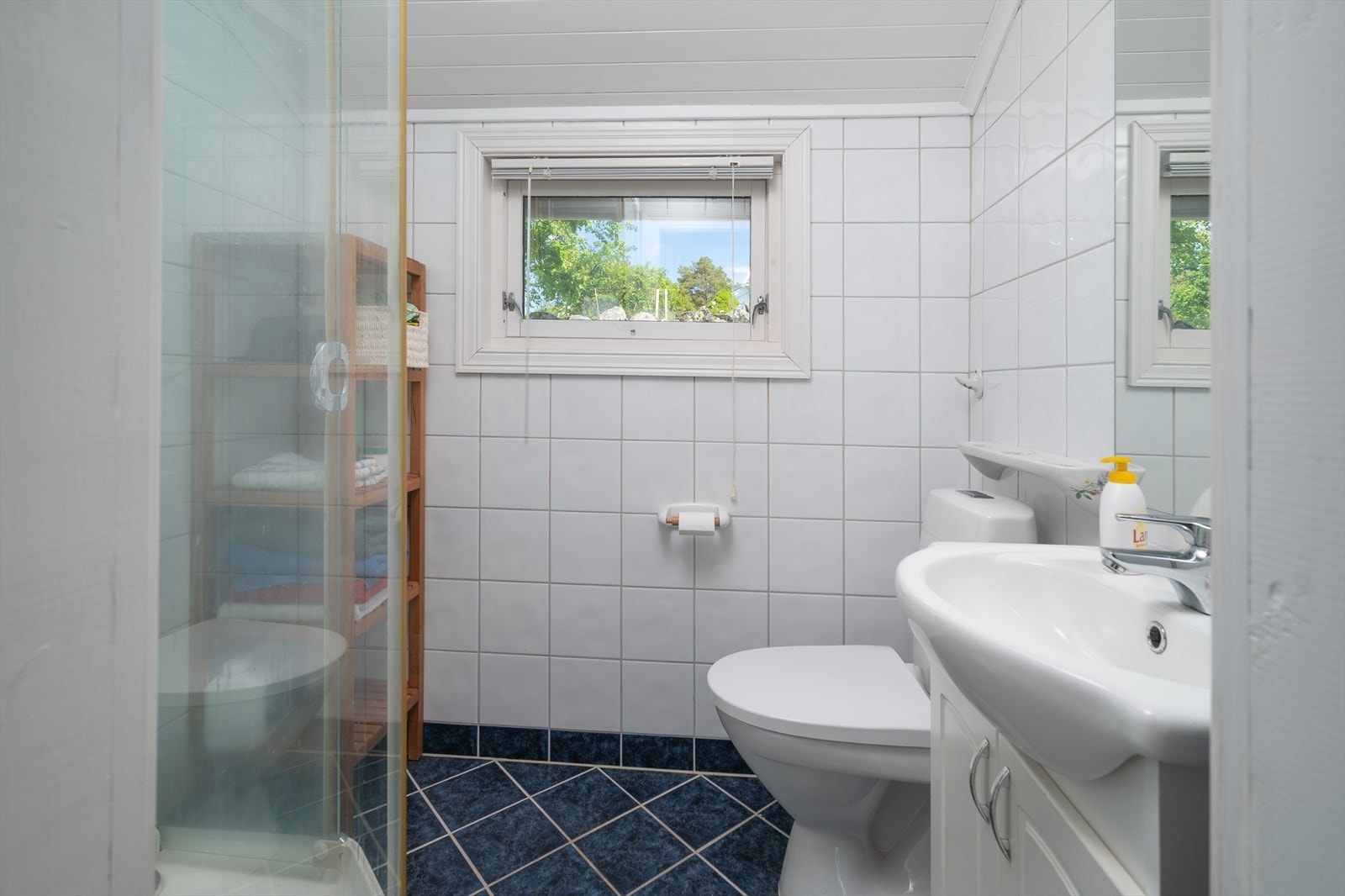 Flislagt bad med dusjkabinett, wc og servant med innredning Galleribilde