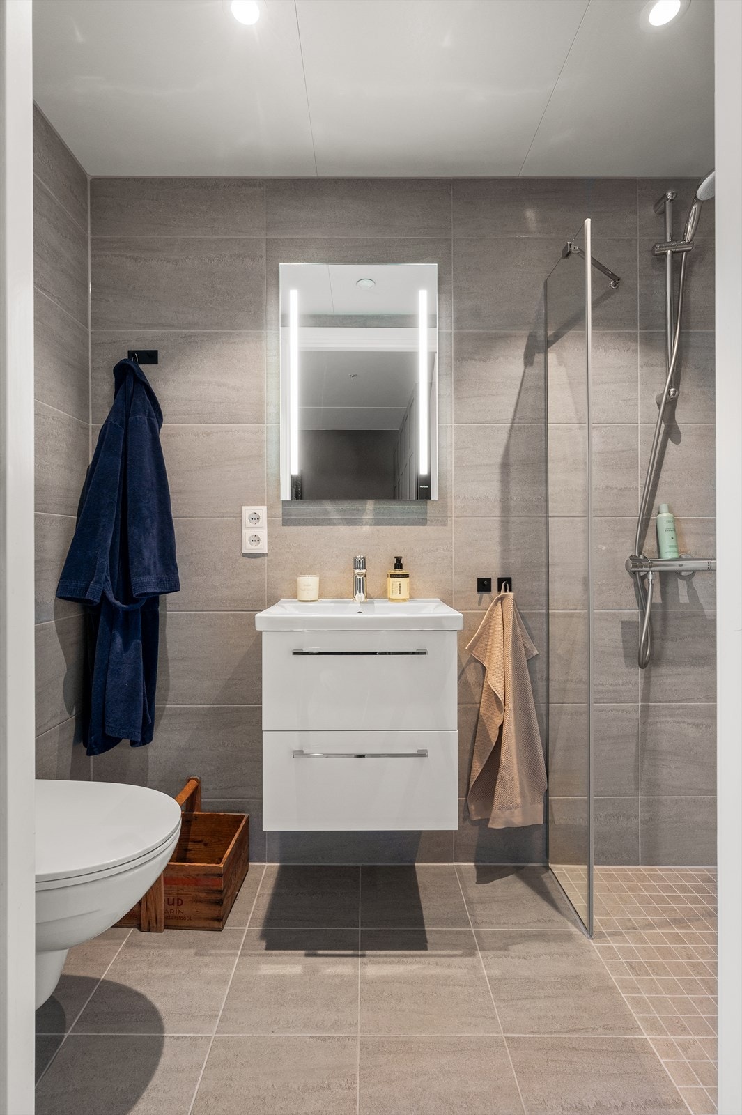 Det private badet tilknyttet hovedsoverommet har innfelte downlights, dusjhjørne og servant i innredning. Galleribilde
