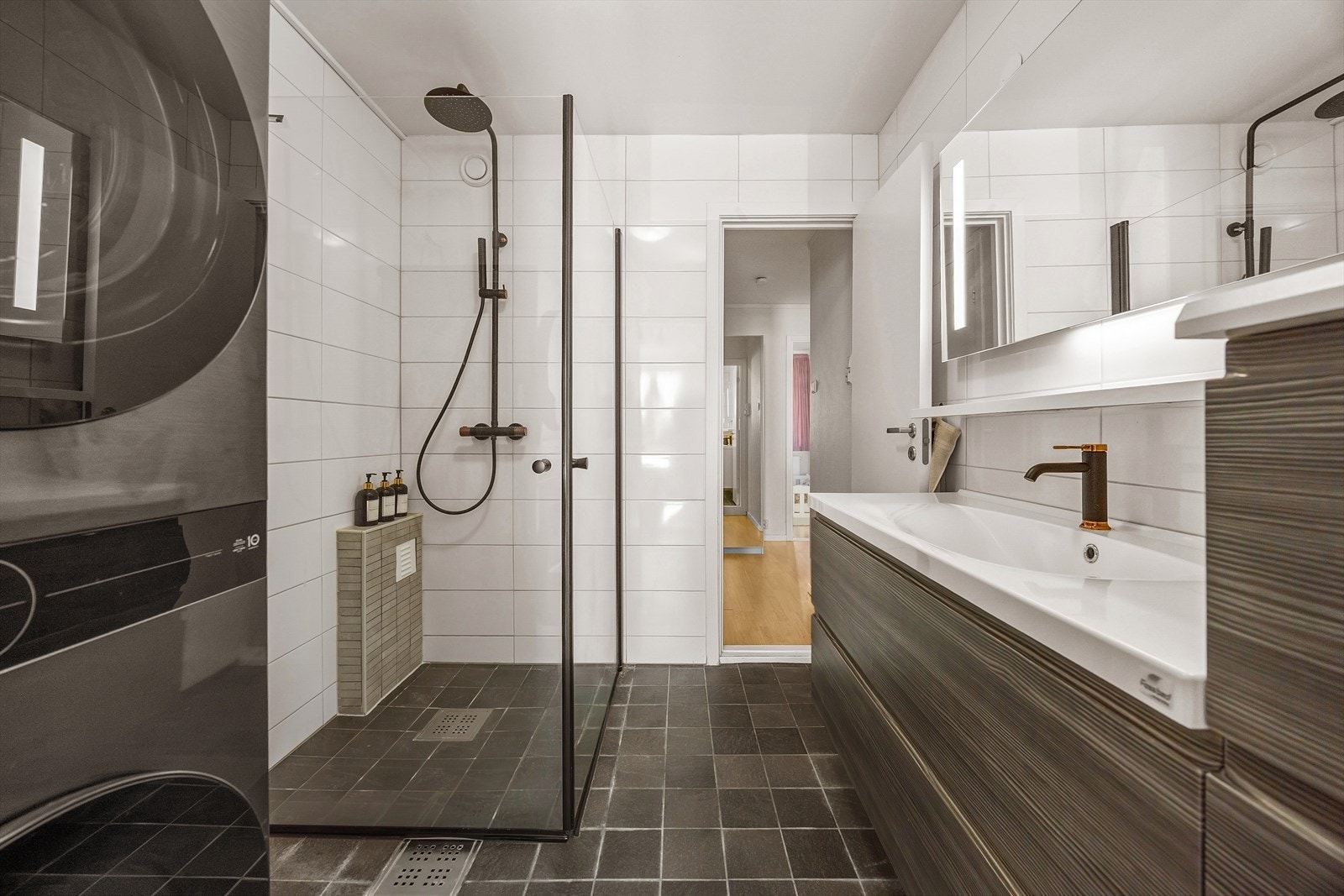 Badet ble delvis oppgradert i 2012, ifølge tidligere salgsopplysninger. Rommet har flislagte vegger og gulv, samt malt betong i himling. Det er elektriske varmekabler i gulvet, som gir god komfort. Galleribilde