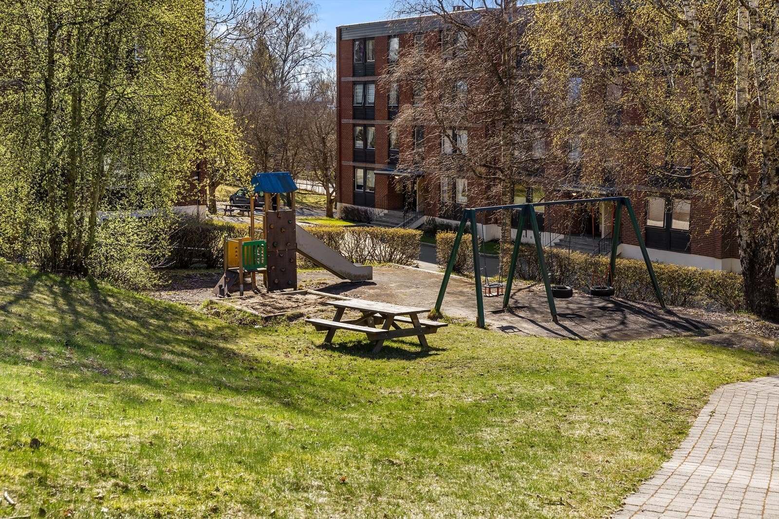 Barnevennlig og hyggelig uteområde med lekeplass, grøntarealer og gode solforhold - et perfekt samlingspunkt for både små og store. Galleribilde