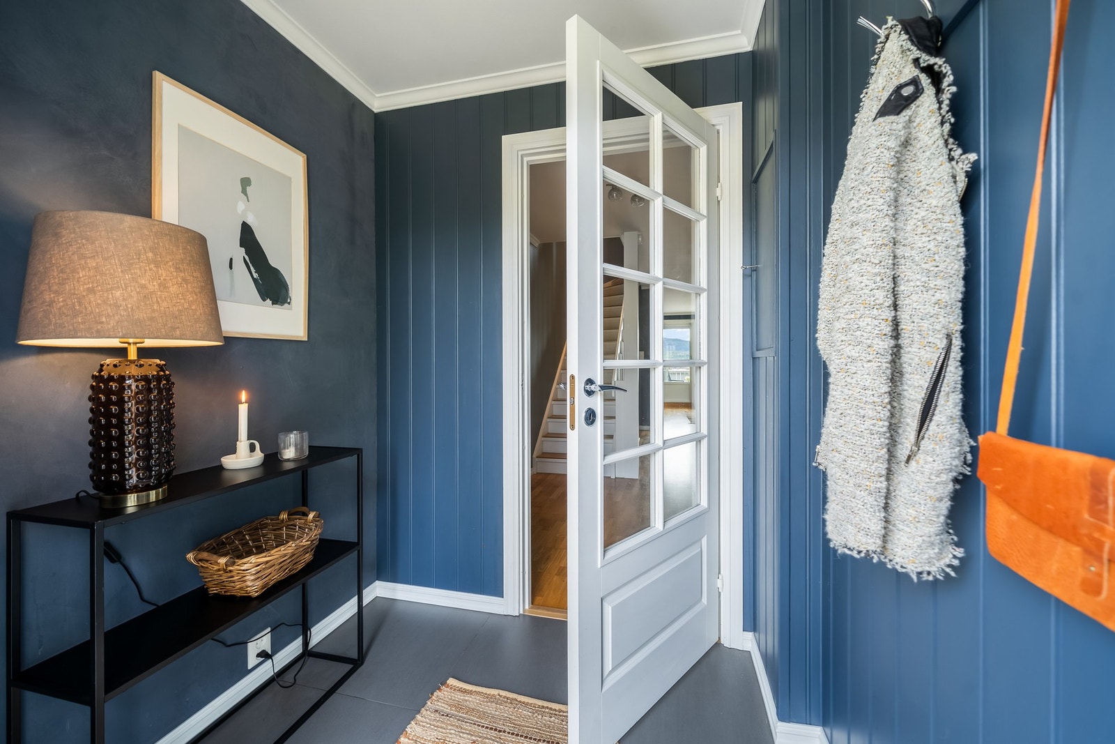Du ønskes velkommen inn i en praktisk entrè som er utstyrt med flis på gulv og panelplater på vegg. Her er det god plass til å henge fra seg yttertøyet. Galleribilde