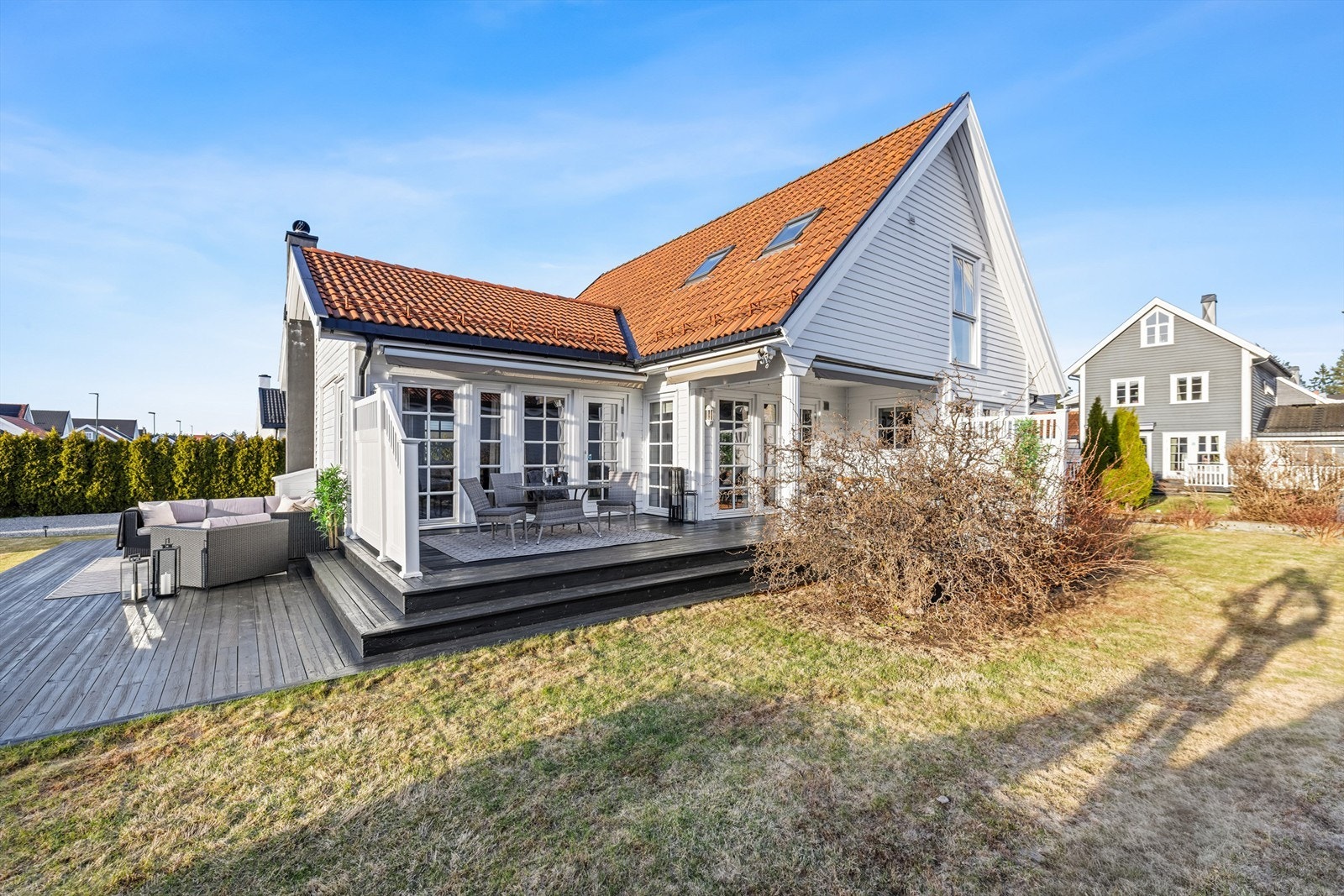 Oversiktsbilde av eiendommen med den store terrassen og hagen. Galleribilde