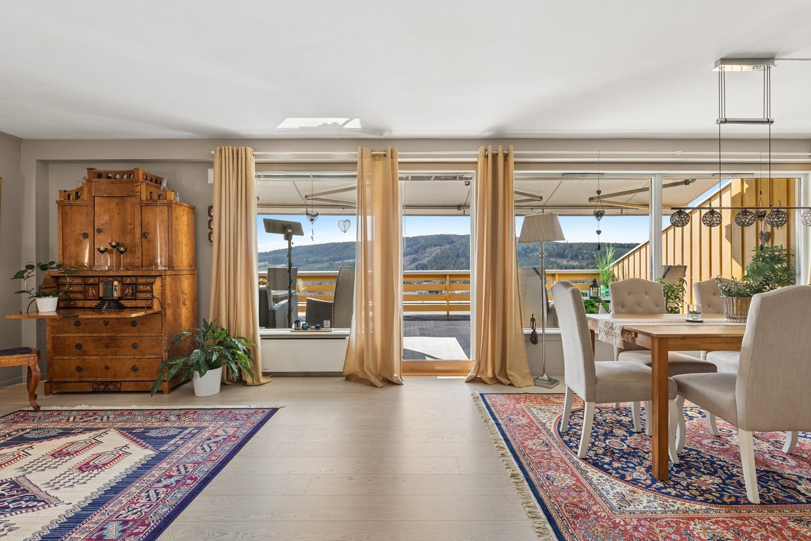 Fra stuen er det utgang til den solrike terrassen. De store vindusflatene gir god lysinnslipp og gjør det mulig å nyte utsikten også innenfra. Galleribilde