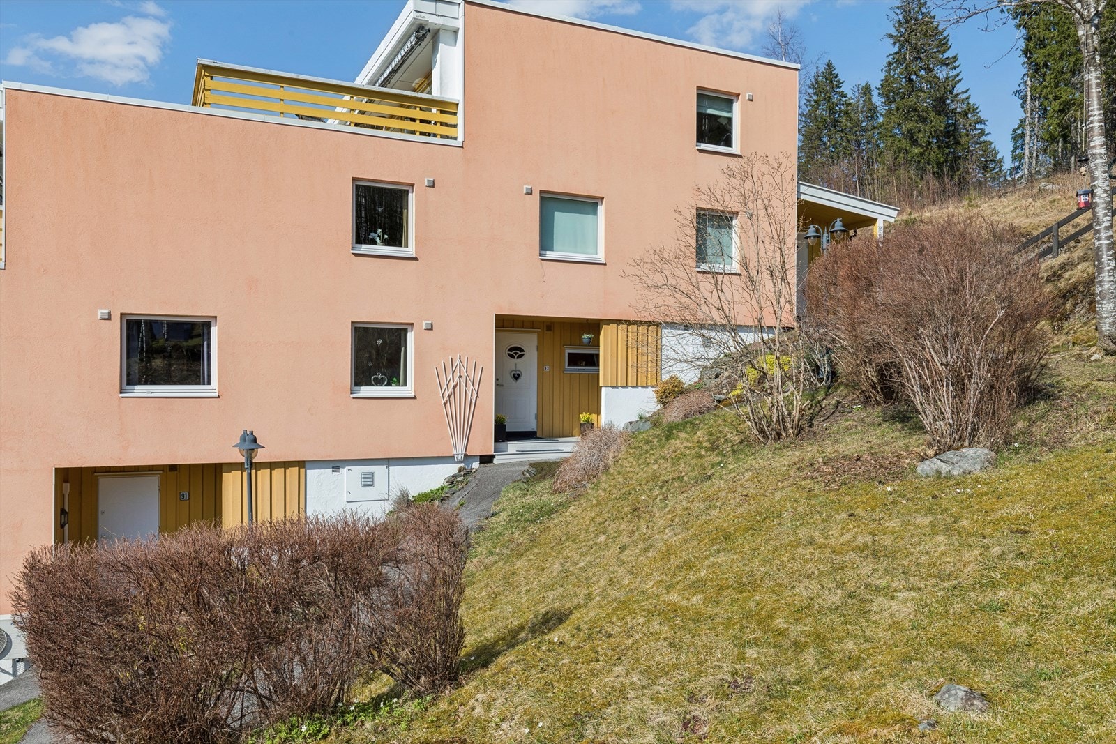 Takoverbygget inngangsparti og pent opparbeidet bed på fremsiden. Galleribilde