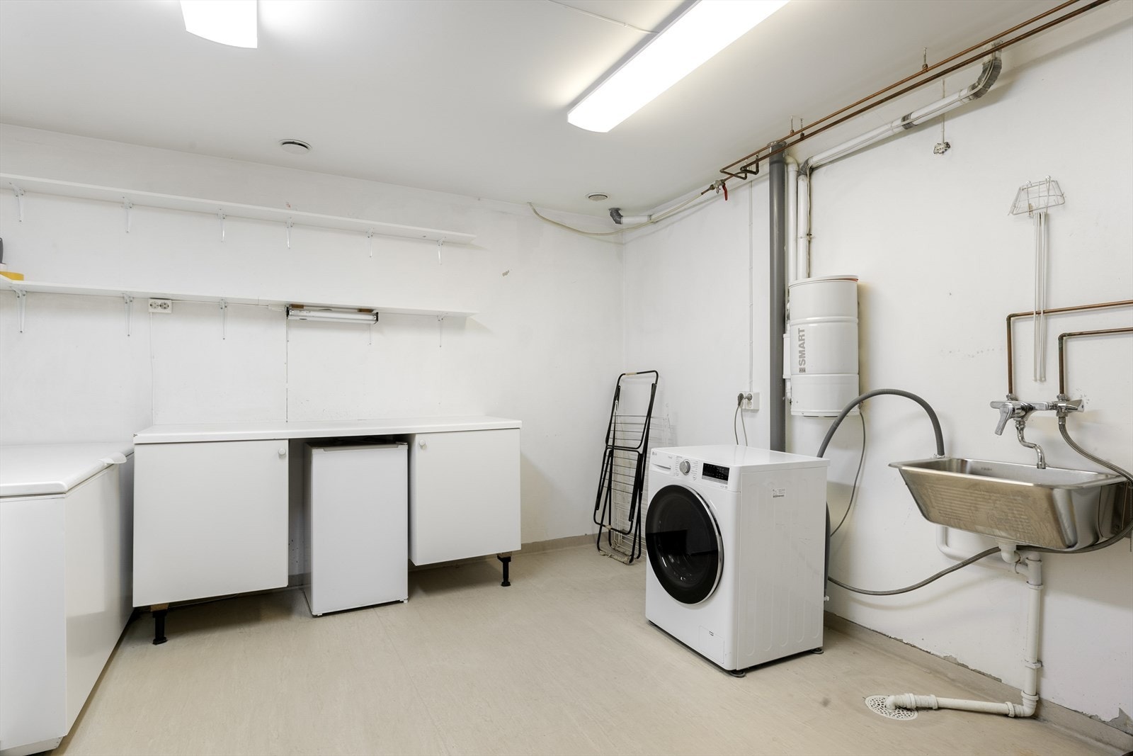 Praktisk og romslig vaskerom i underetasjen med utslagsvask og god lagringsplass. Galleribilde