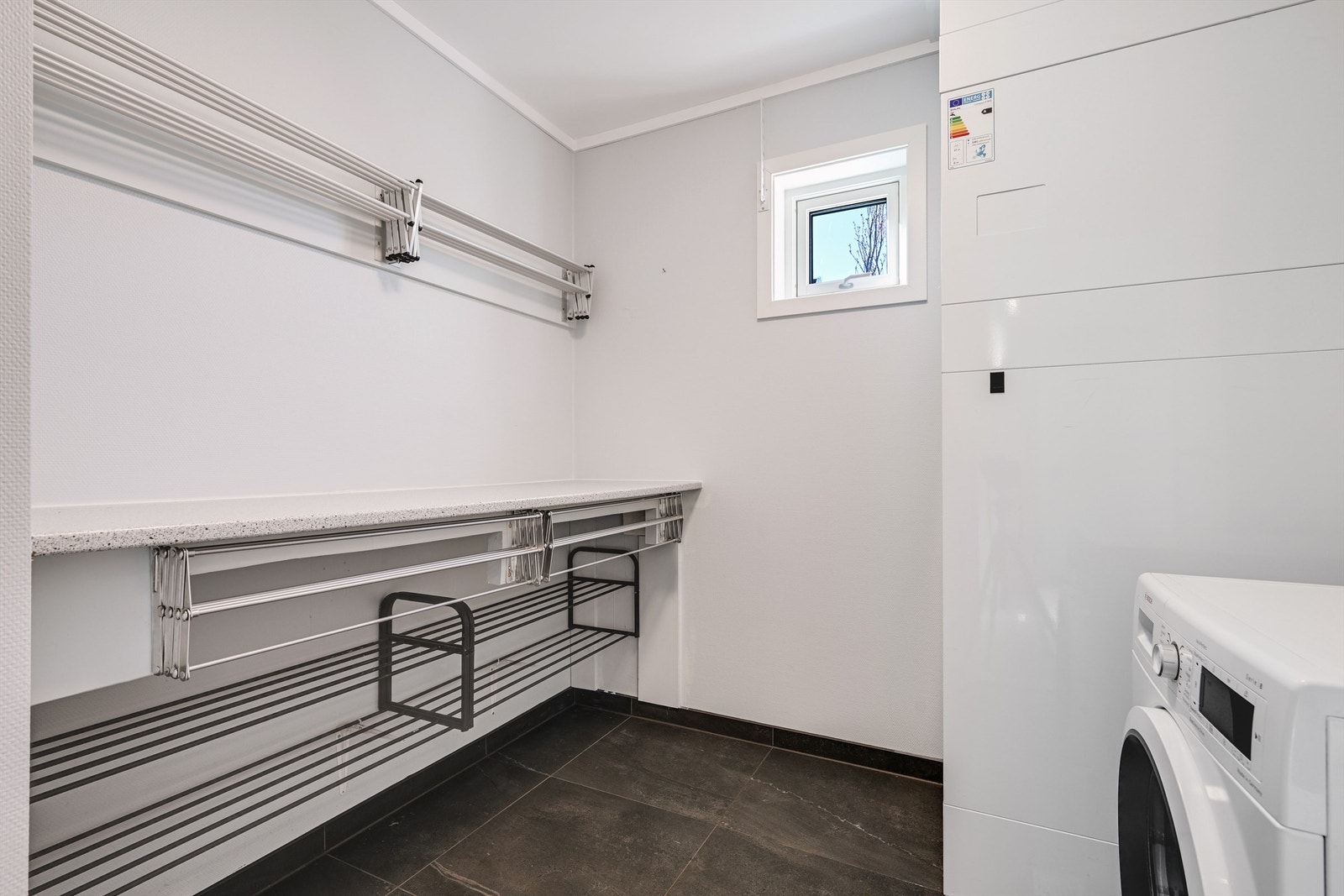 Praktisk, separat vaskerom med flislagt gulv, elektriske varmekabler og opplegg for vaskemaskin. Galleribilde