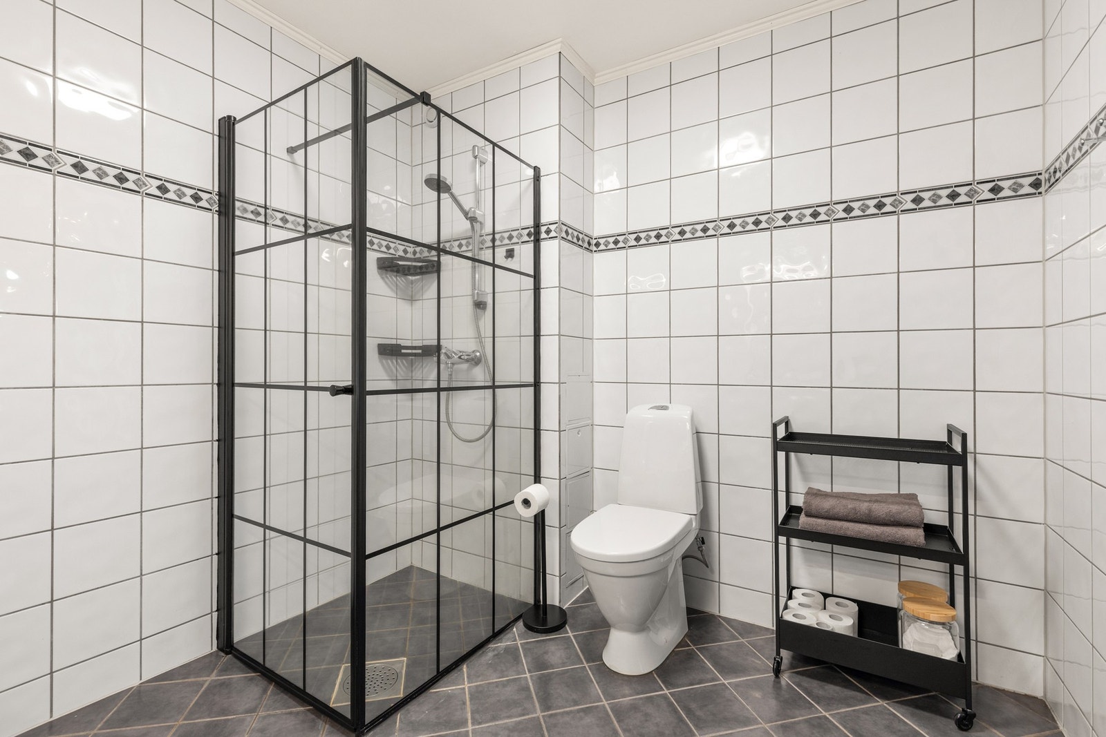 Videre er badet utstyrt med dusjhørne og gulvstående toalett Galleribilde