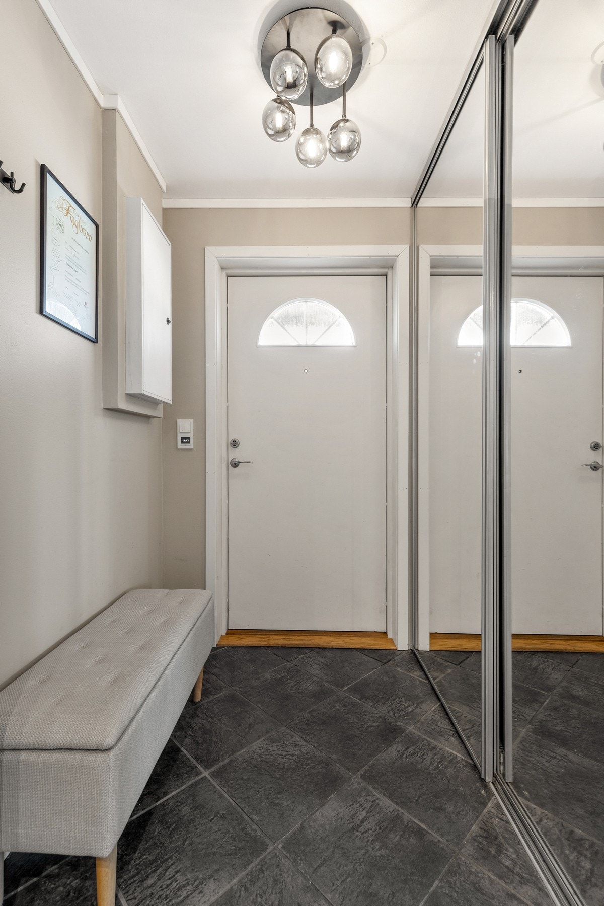 Det er montert skyvedørsgarderobe med speilfronter for oppbevaring av yttertøy og sko Galleribilde