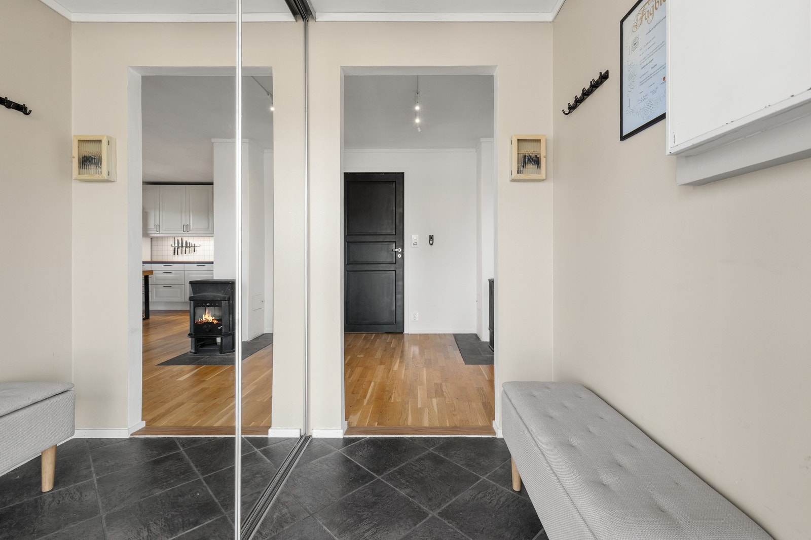 Romslig entré med fliser på gulv og slette flater på vegger og i himling Galleribilde
