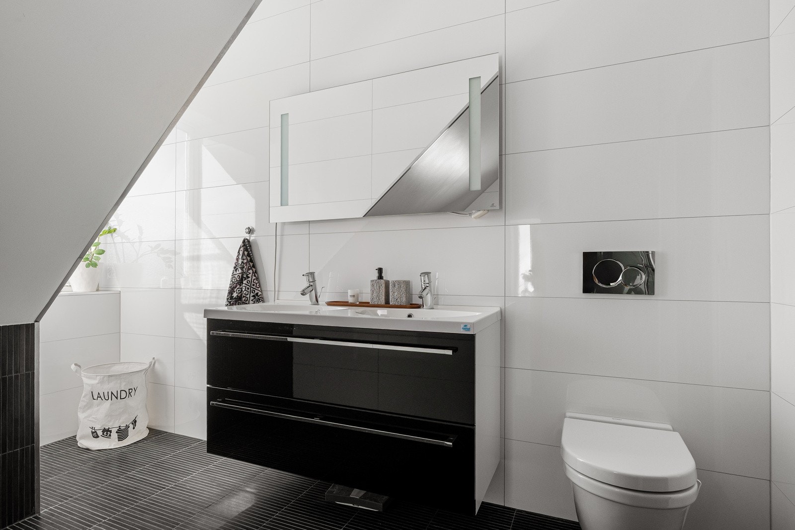 Praktisk vegghengt toalett og mye oppbevaringsplass i baderomsinnredningen.