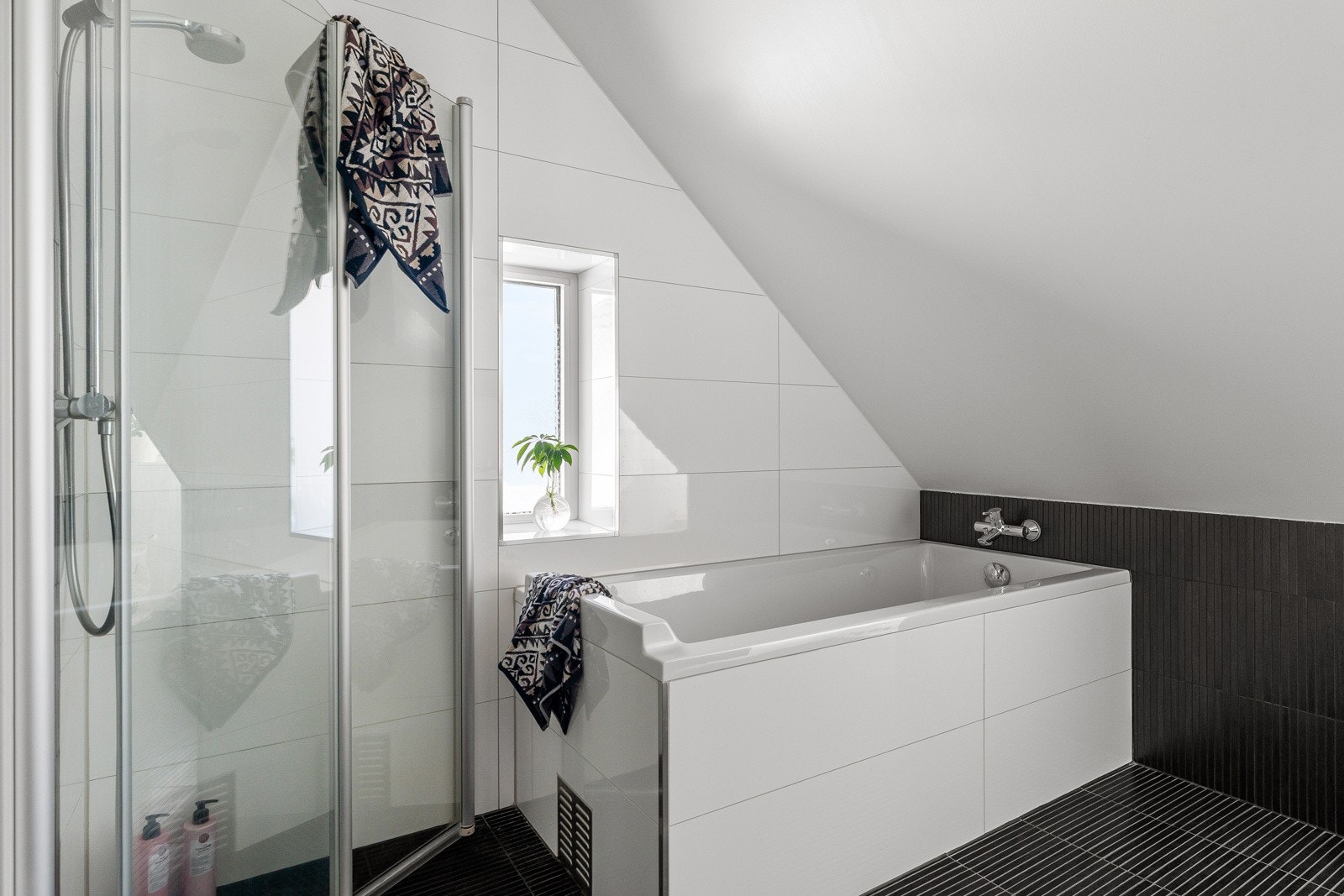 Baderommet har to vinduer som slipper inn mye naturlig dagslys og gir nydelige lysforhold.